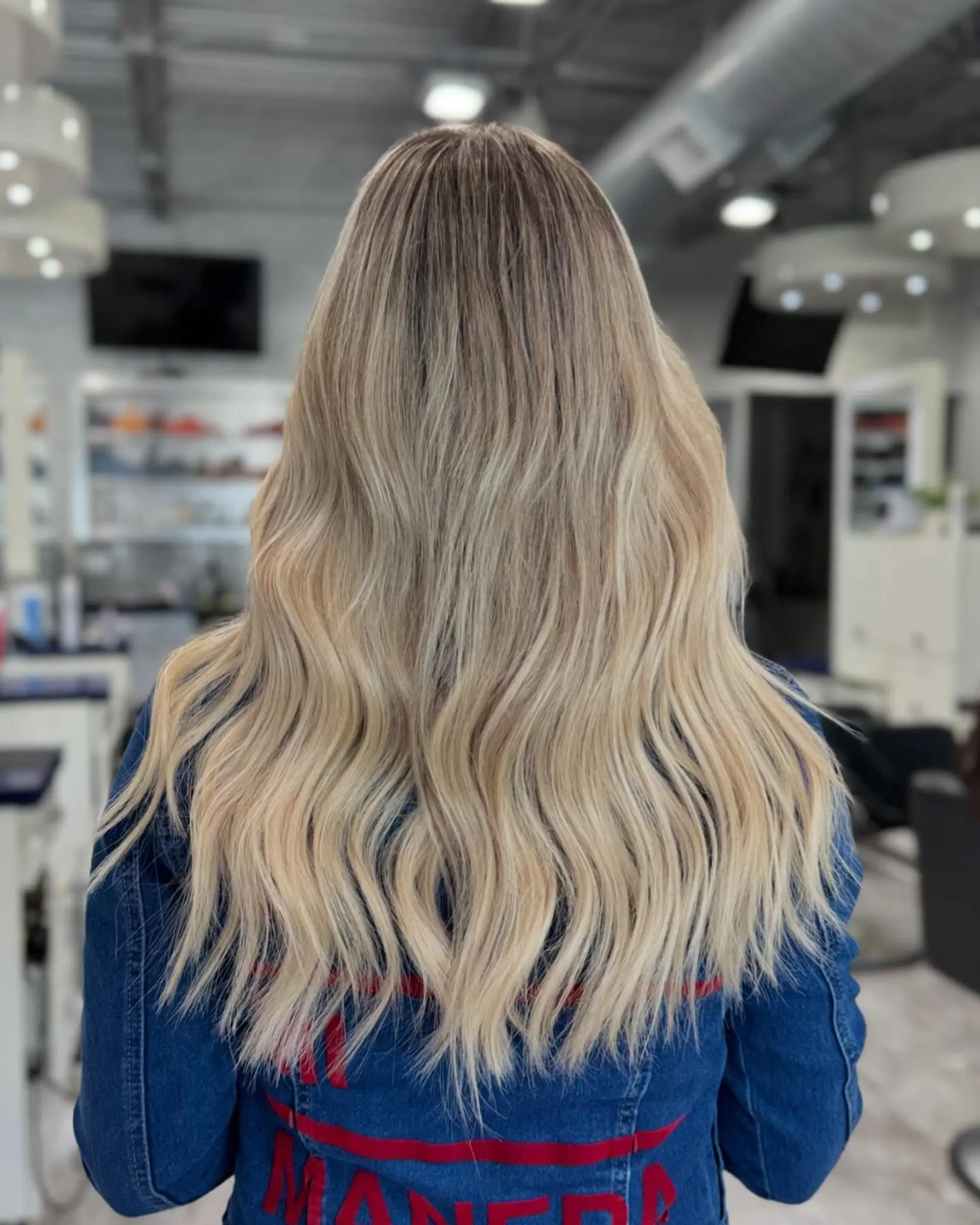 Long, wavy hair with a buttery blonde balayage and natural roots. 3