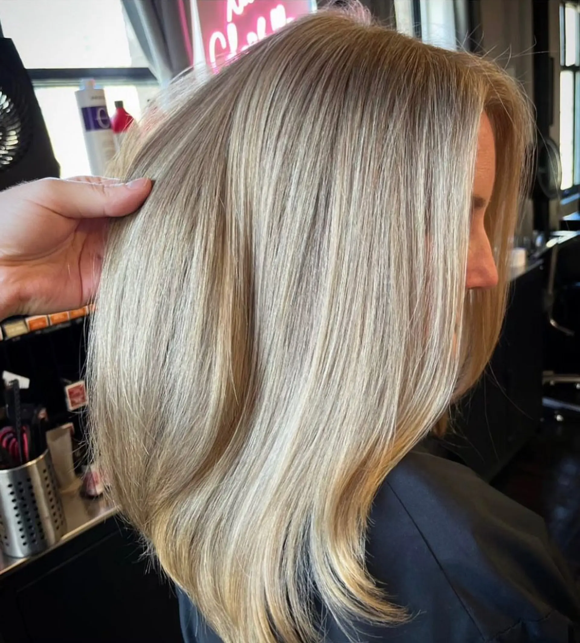 Medium-length straight blonde hair featuring bright, multi-tonal cool blonde highlights and a smooth blowout finish. 1