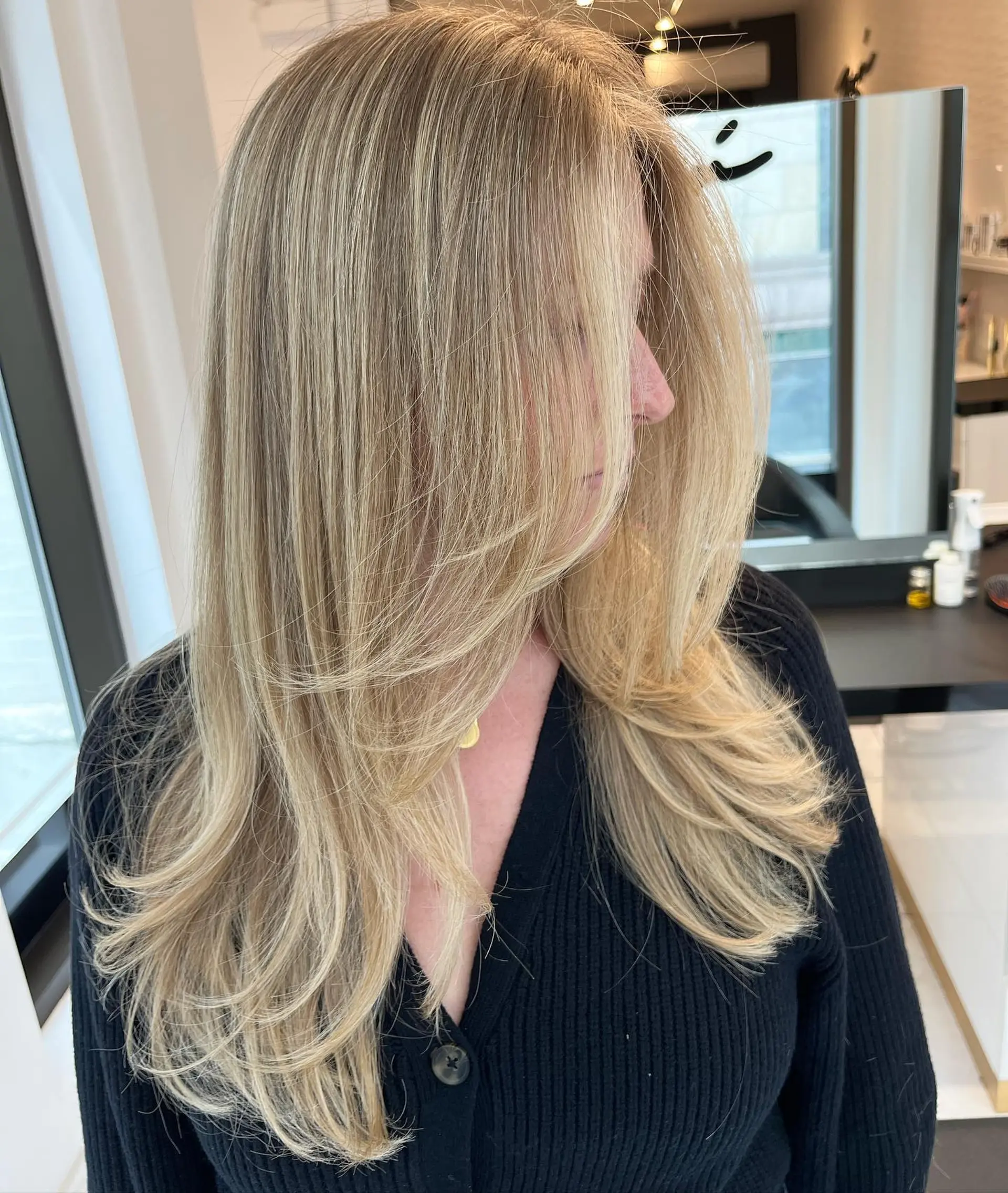 A layered haircut with face-framing layers and a cream blonde balayage. 1