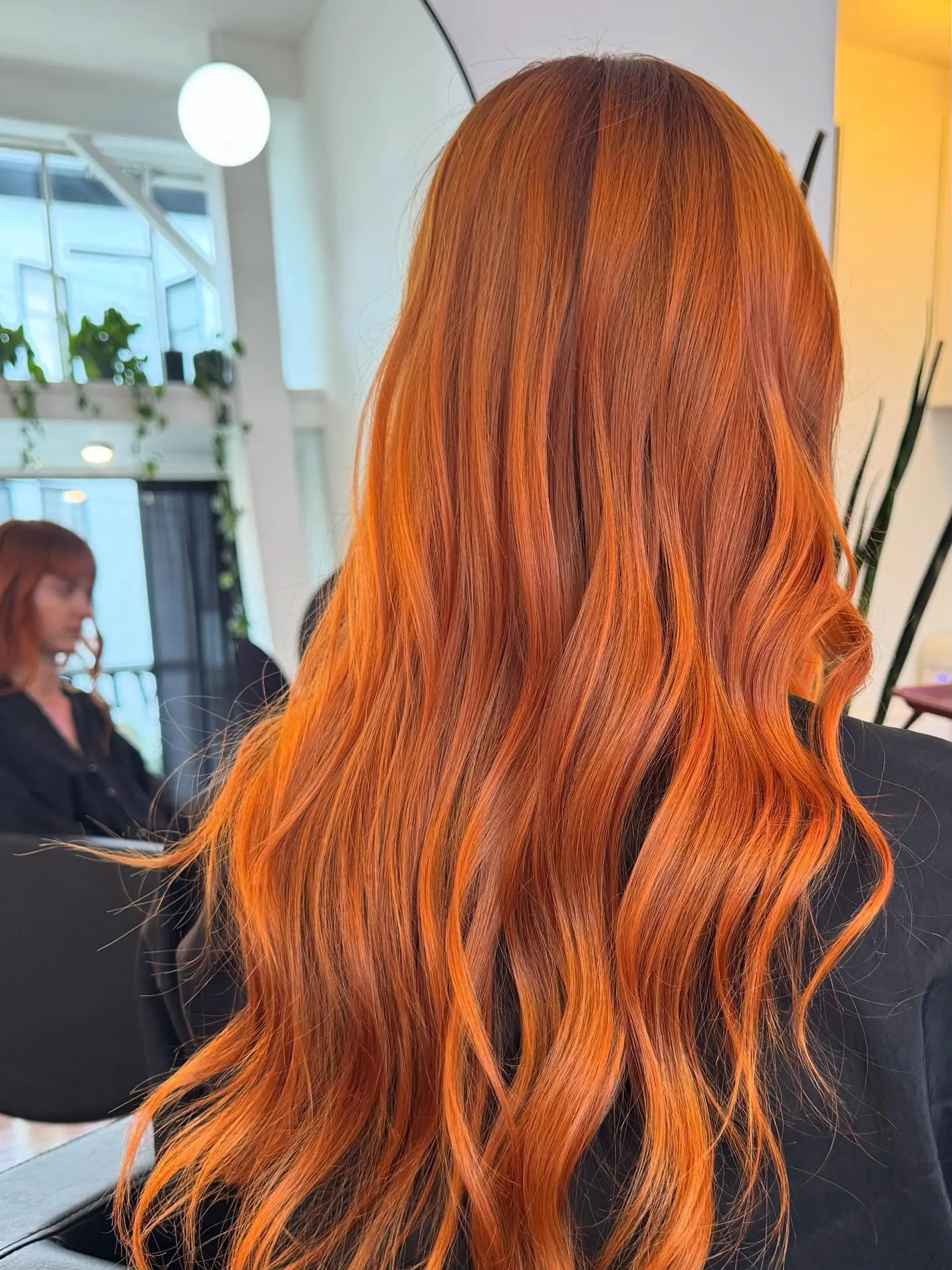 Long, vivid copper-orange hair styled into soft, flowing waves. 1