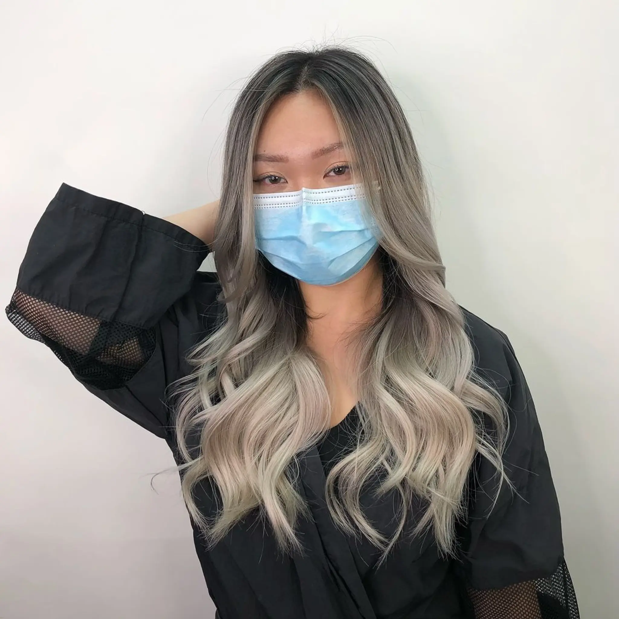 Long wavy hair with an ombre effect, transitioning from dark brown roots to silver ends, featuring soft waves and a center part with face-framing highlights.
Stylist - @xcellent_jason