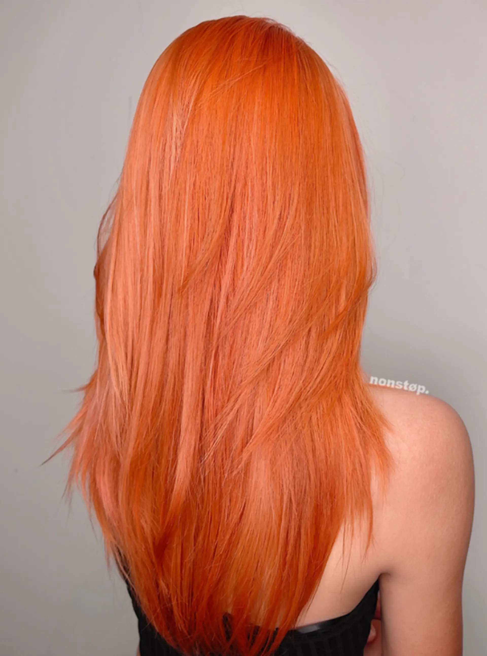 Long, straight, vibrant orange hair with layers for texture and volume. A middle part divides the hair, allowing layers to frame the face. 2