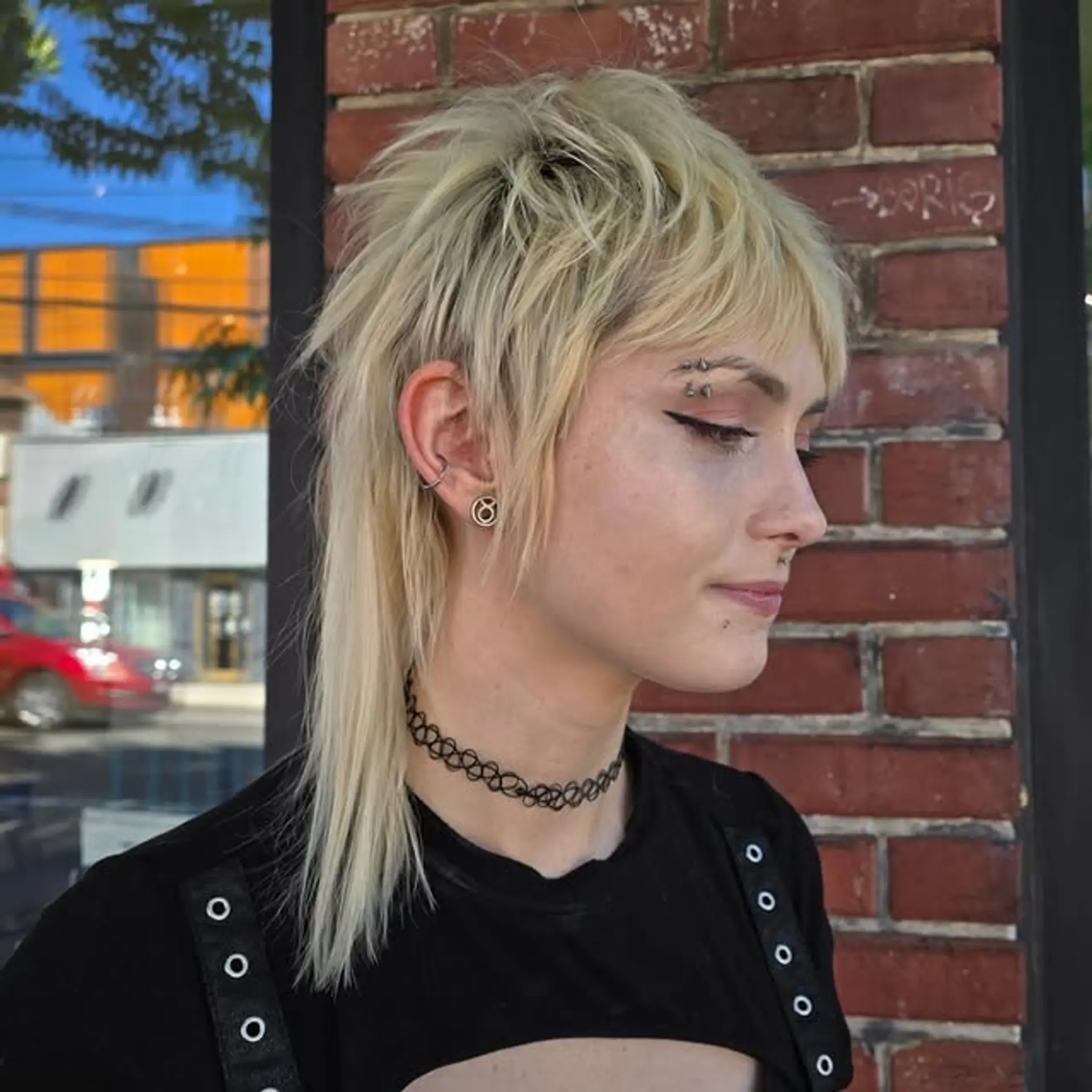 A platinum blonde shaggy mullet with short, choppy layers on the top and sides with longer hair in the back. 1