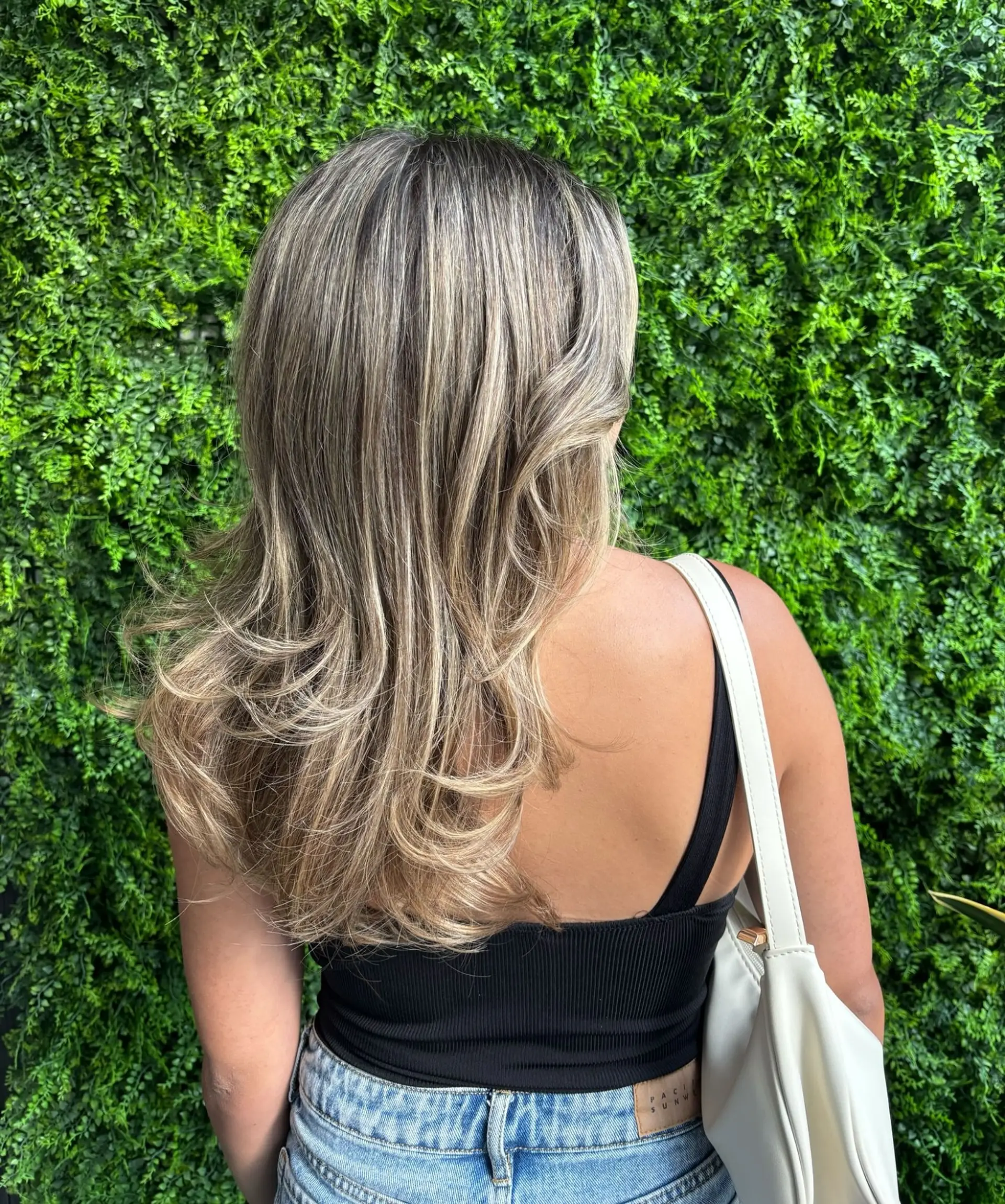 A medium-length, wavy hairstyle with a bronde balayage. 3