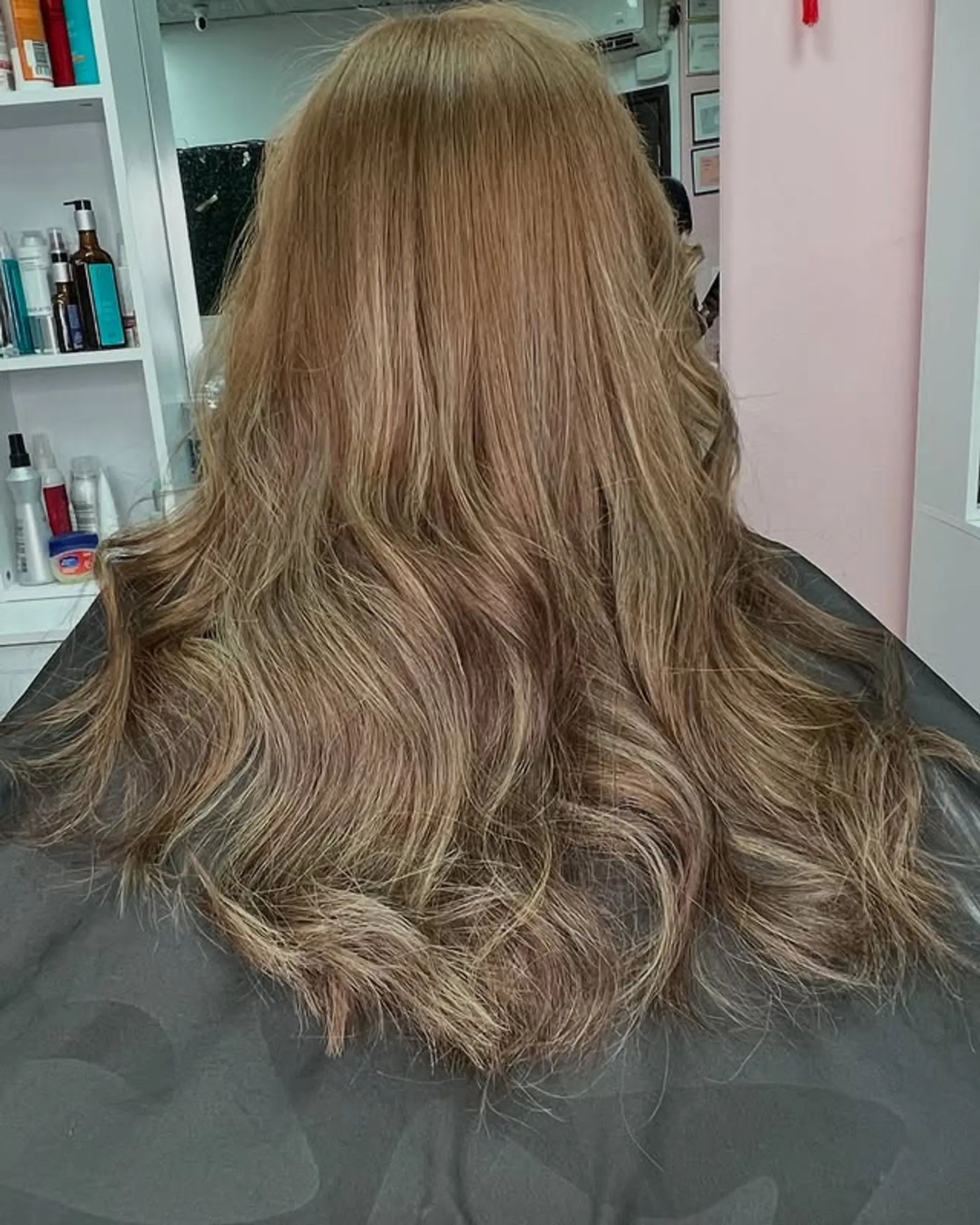 A long, wavy hairstyle with caramel and blonde balayage tones. 1