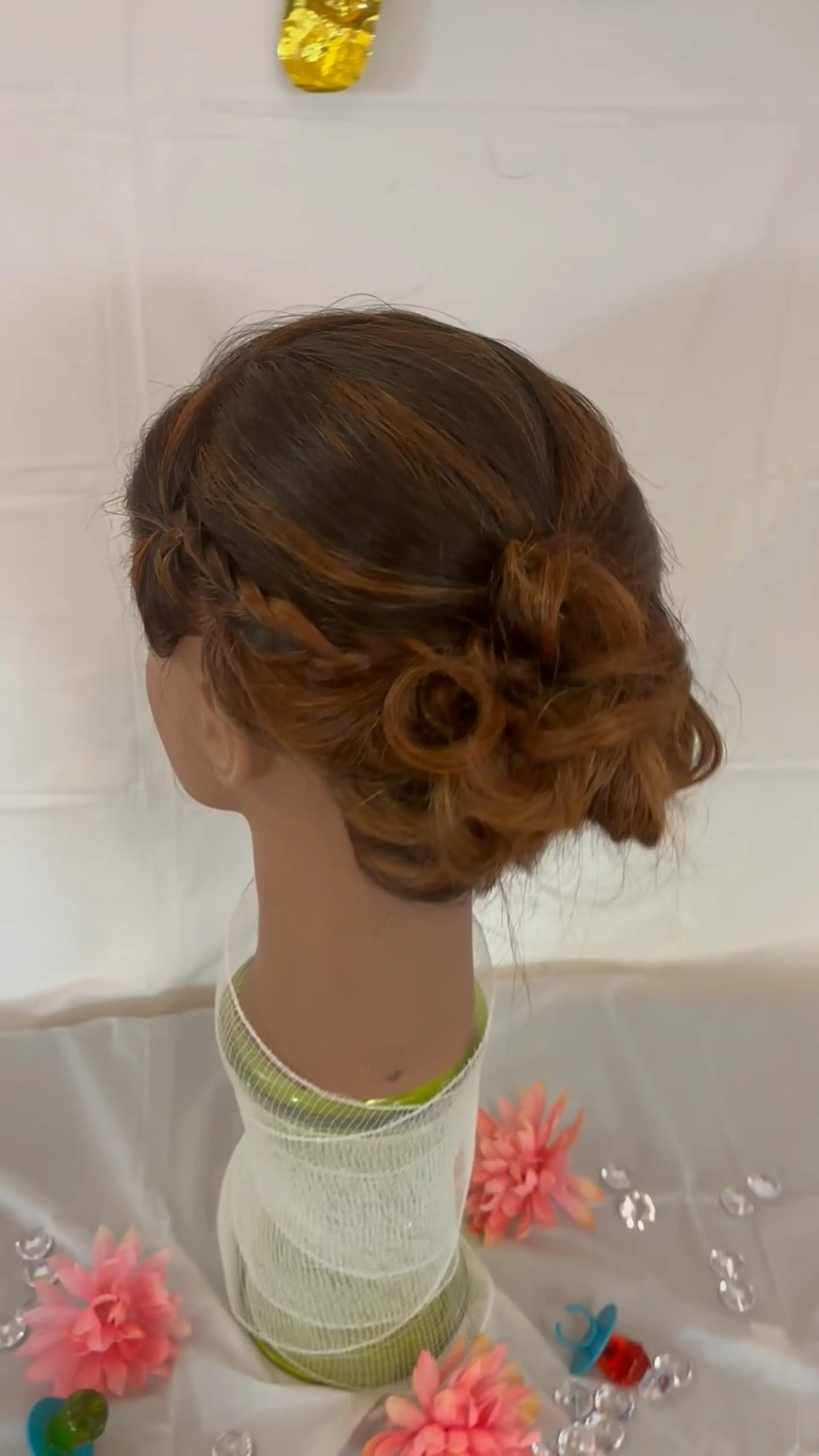 A side-swept accent braid pinned into a textured, curly low bun. 1