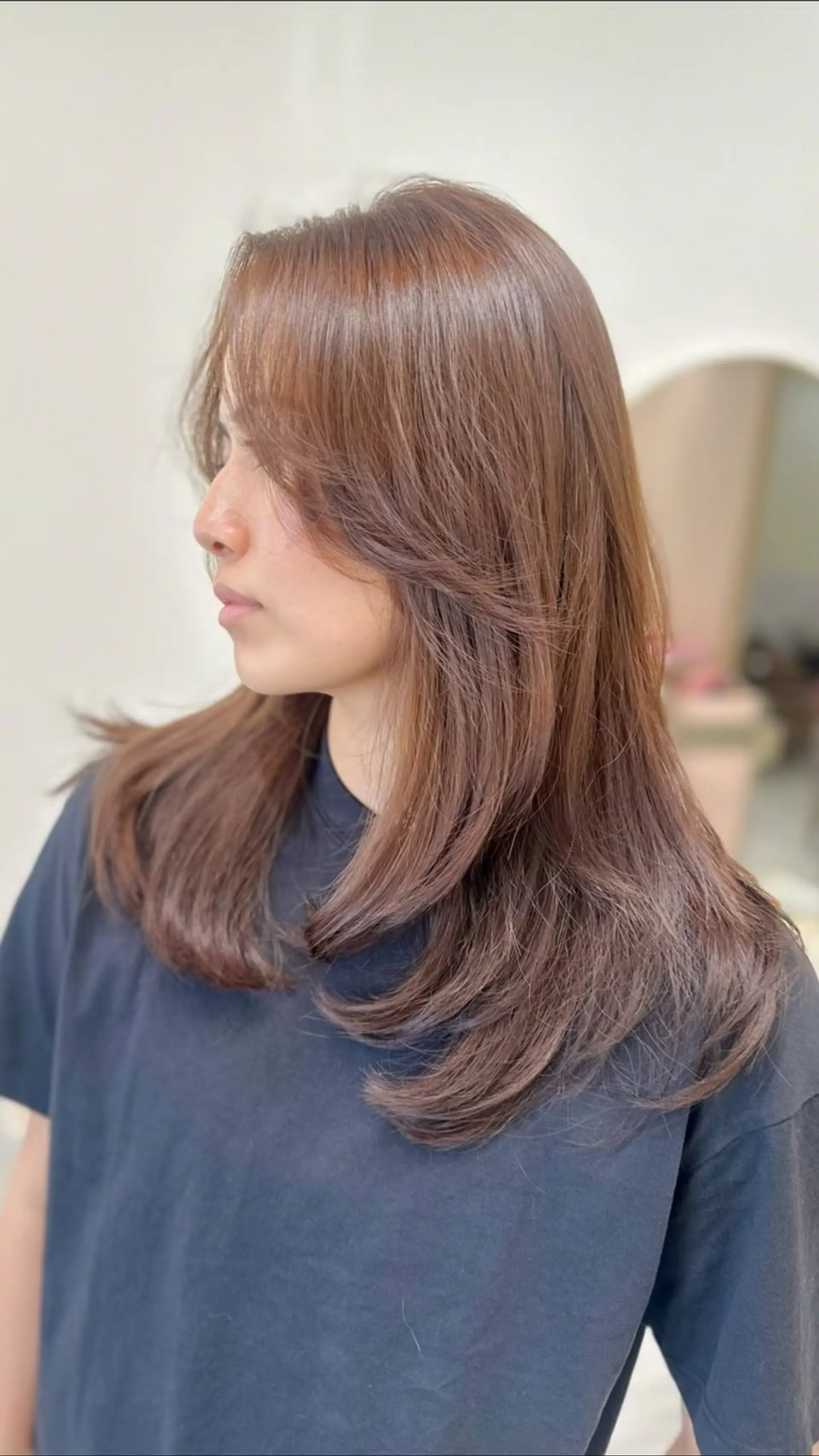 A long, dimensional layered haircut in a cool brown tone with sweeping face-framing layers. 1