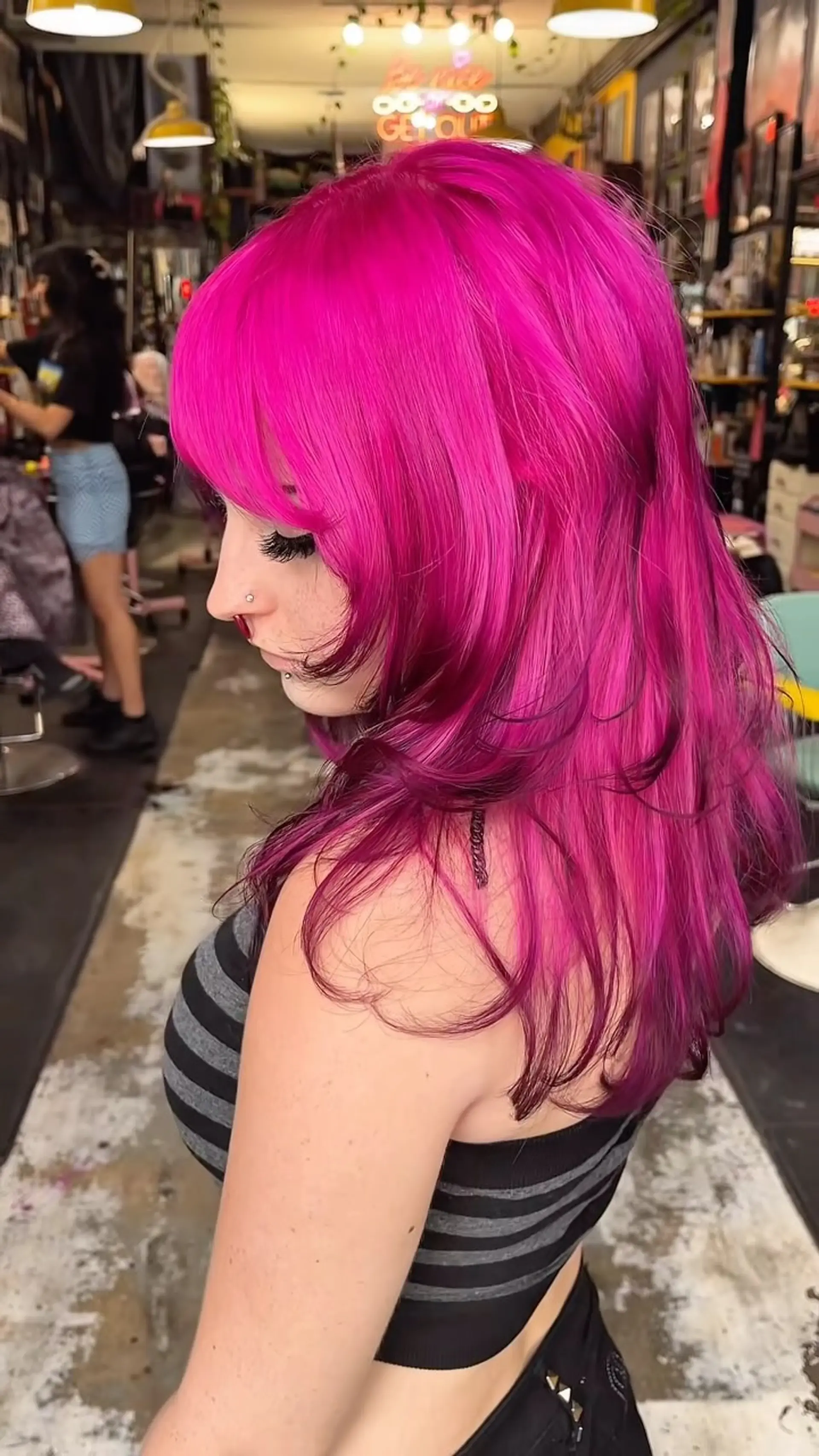 Vibrant hot pink medium-length layered cut with rounded bangs, feathered face-framing layers, and softly curled ends. 1