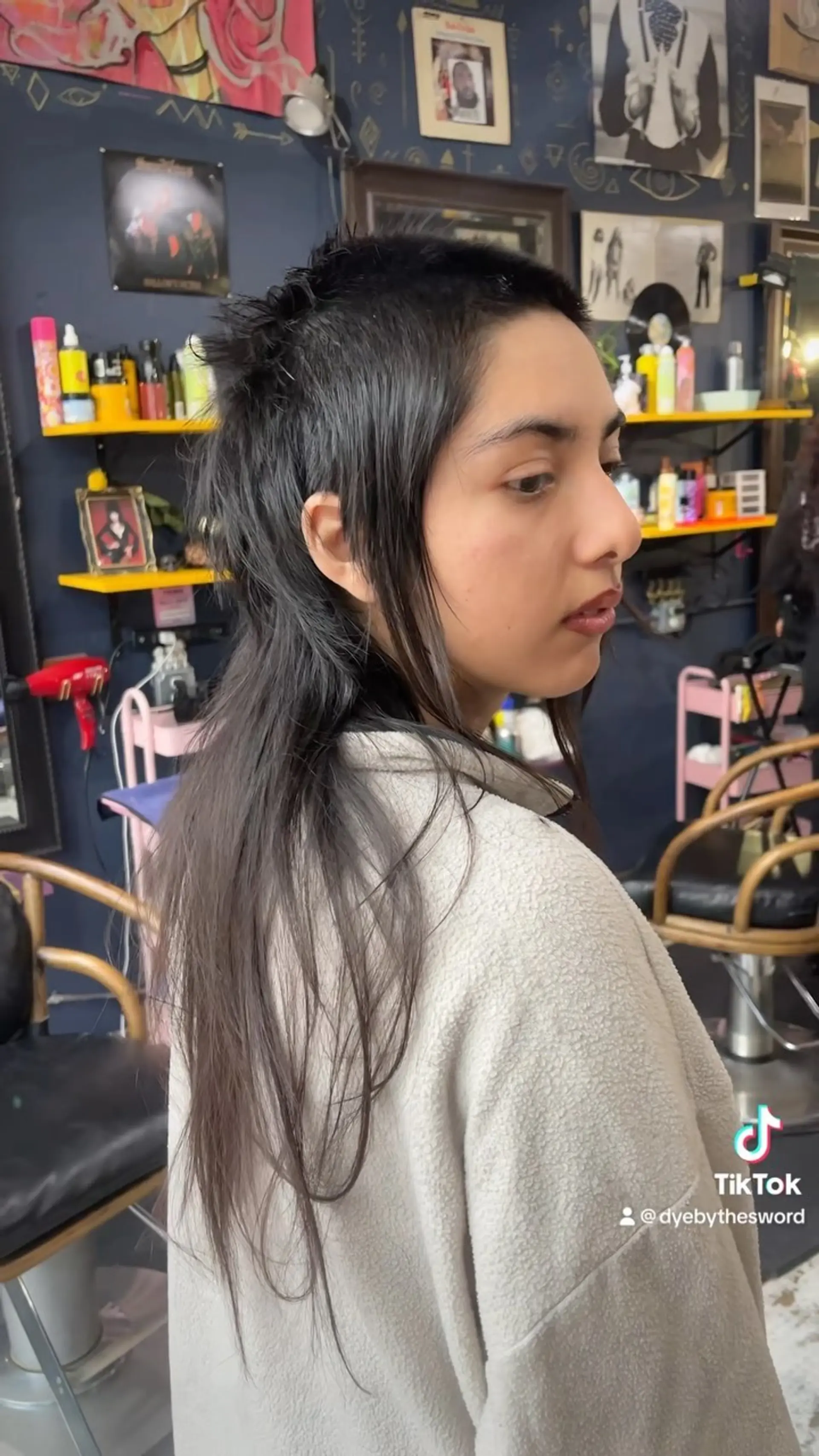 An edgy skullet hairstyle featuring a buzzed, textured crown with short sides and contrasting wispy, long layers flowing down the back. 1