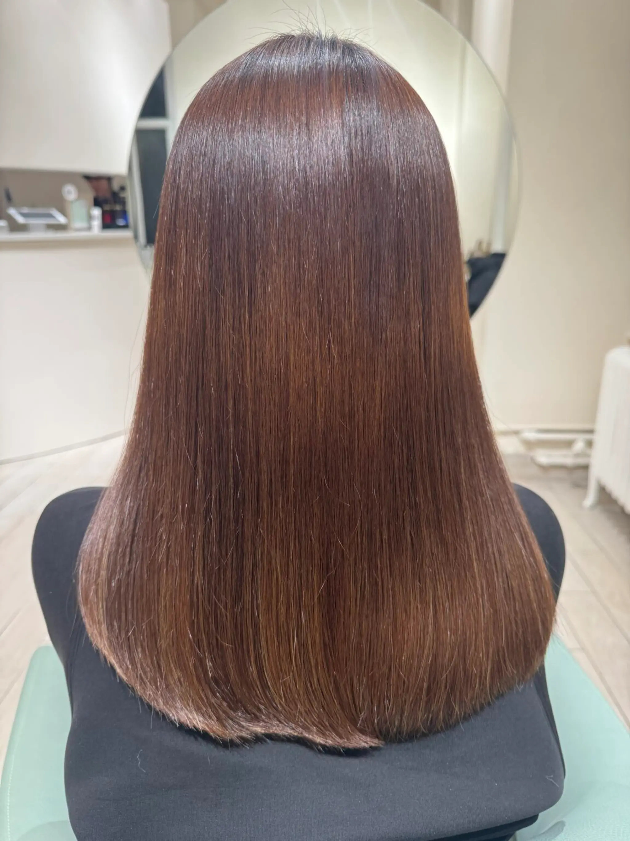 A sleek medium-length hairstyle with straight, glossy, and smooth brown hair.