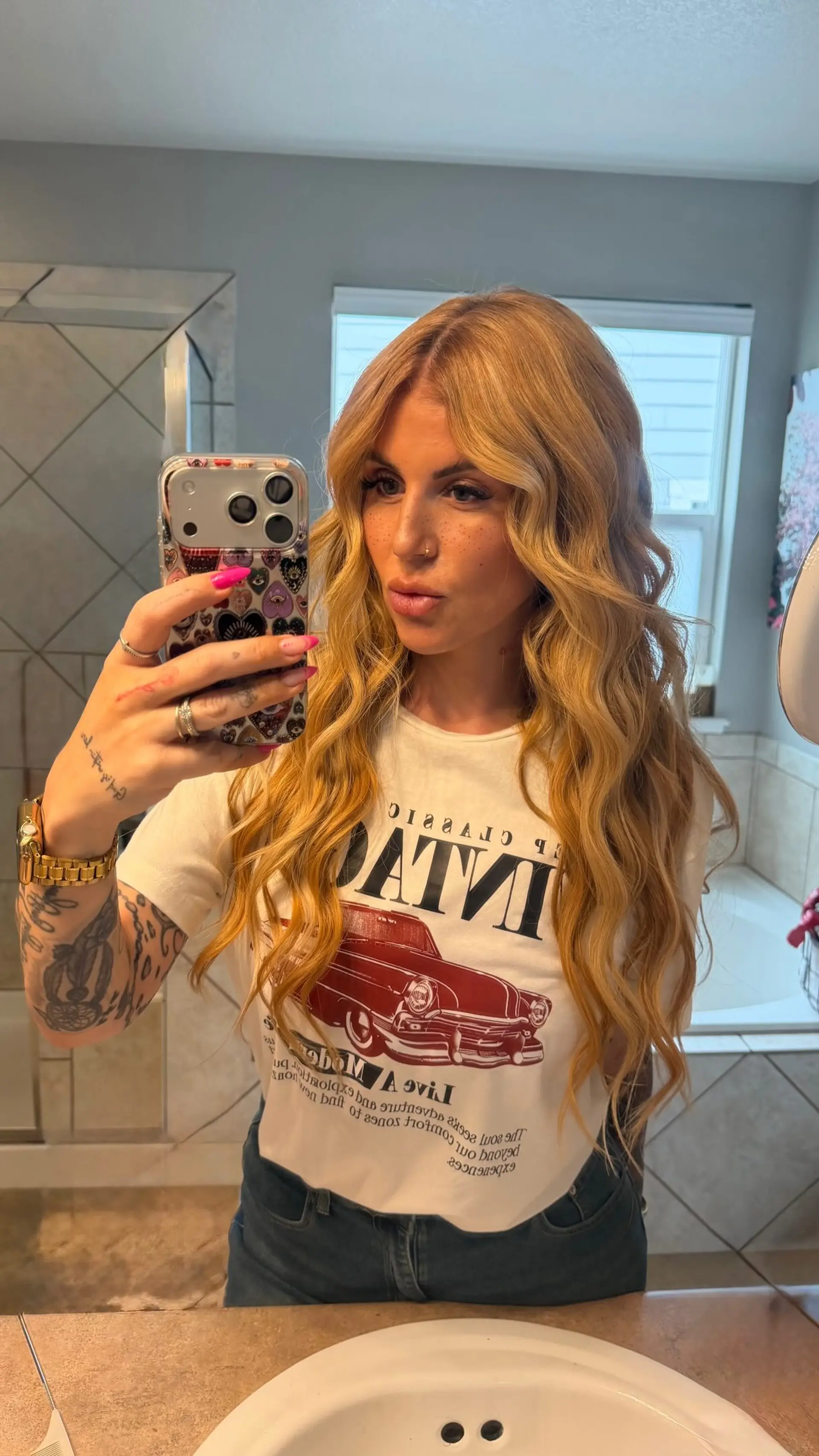 Long warm golden blonde hair styled with soft, voluminous waves and a center part. 1