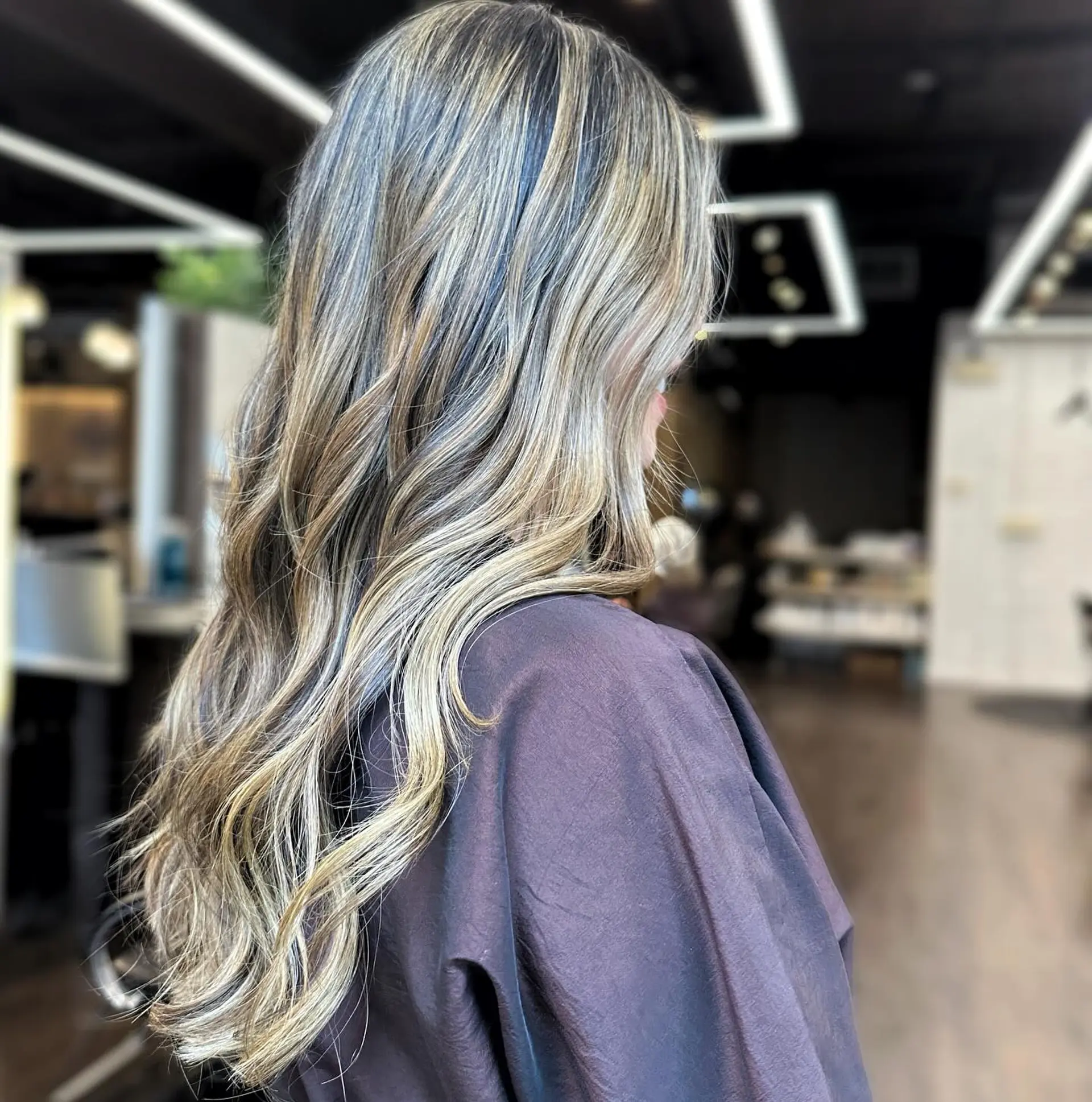 Long, layered hair with an ash blonde balayage and beachy waves. 1