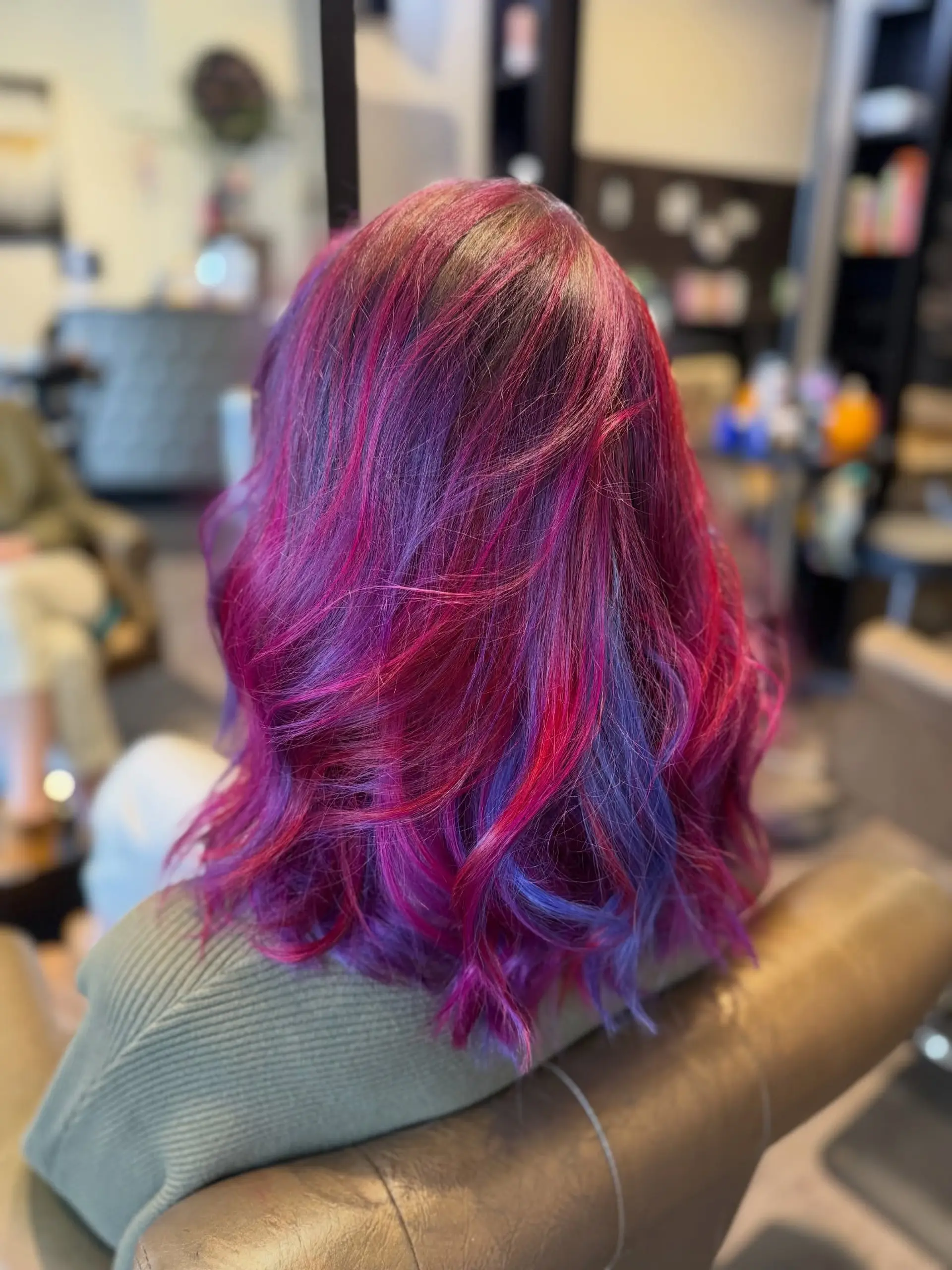 Shoulder-length textured waves featuring vibrant multi-tonal shades of magenta, purple, and blue. 1