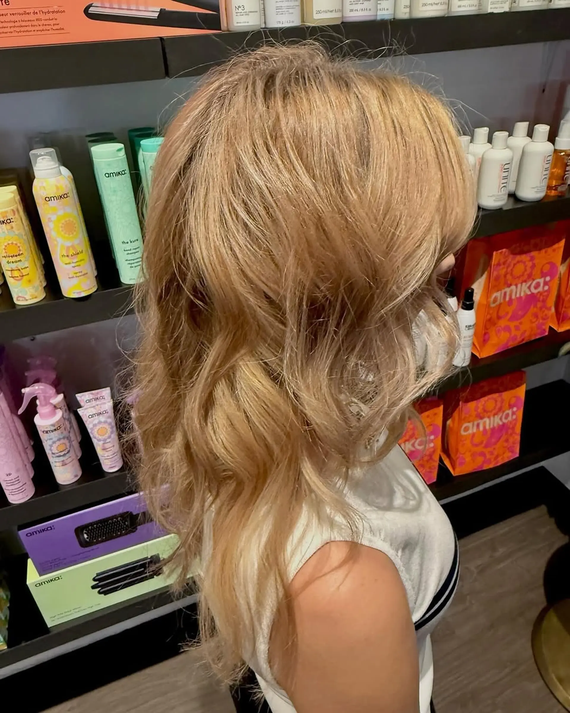Long warm golden blonde hair styled in loose, textured waves falling gracefully past the shoulders. 1