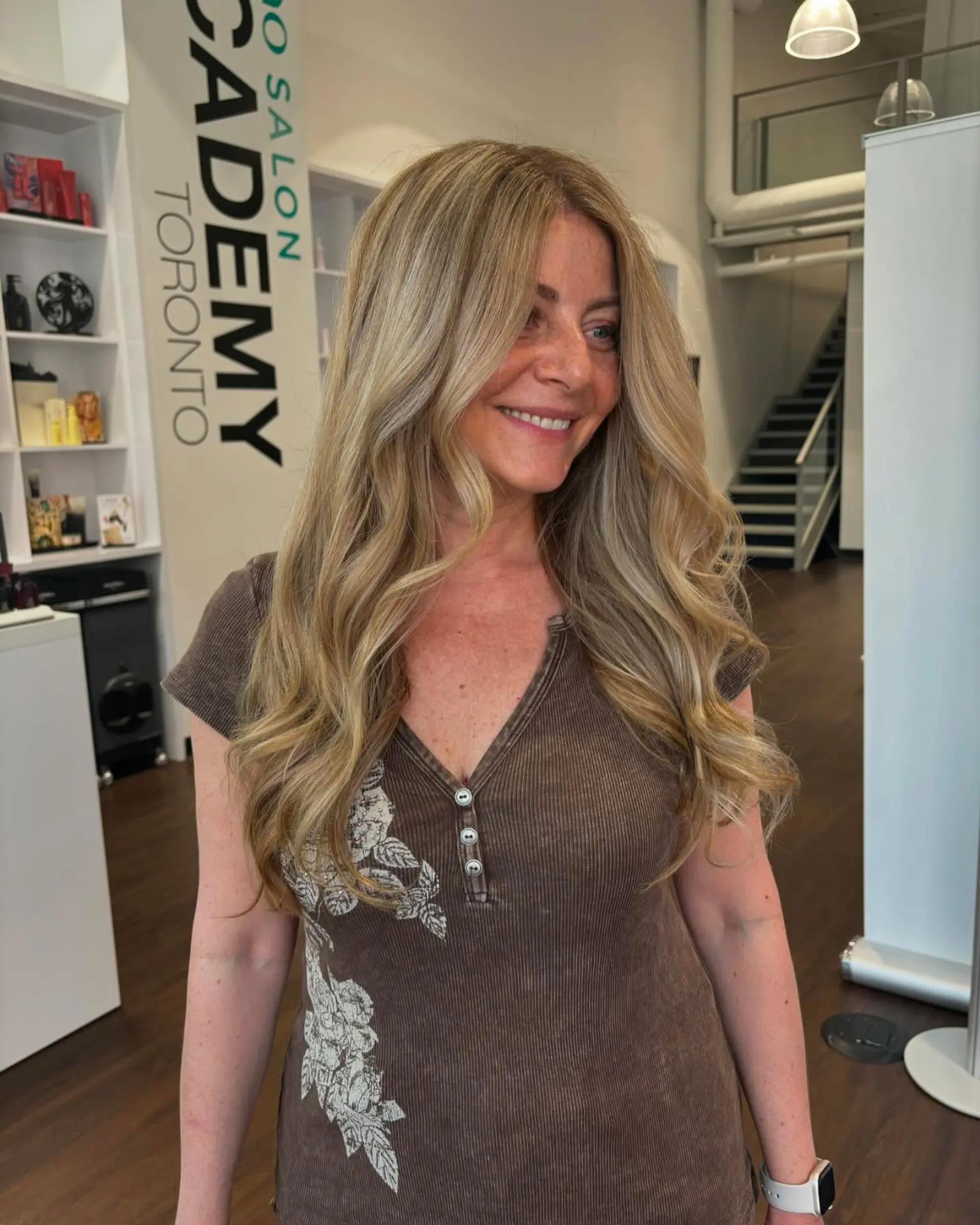 Long multi-dimensional blonde hair styled with soft, cascading waves and face-framing layers. 1