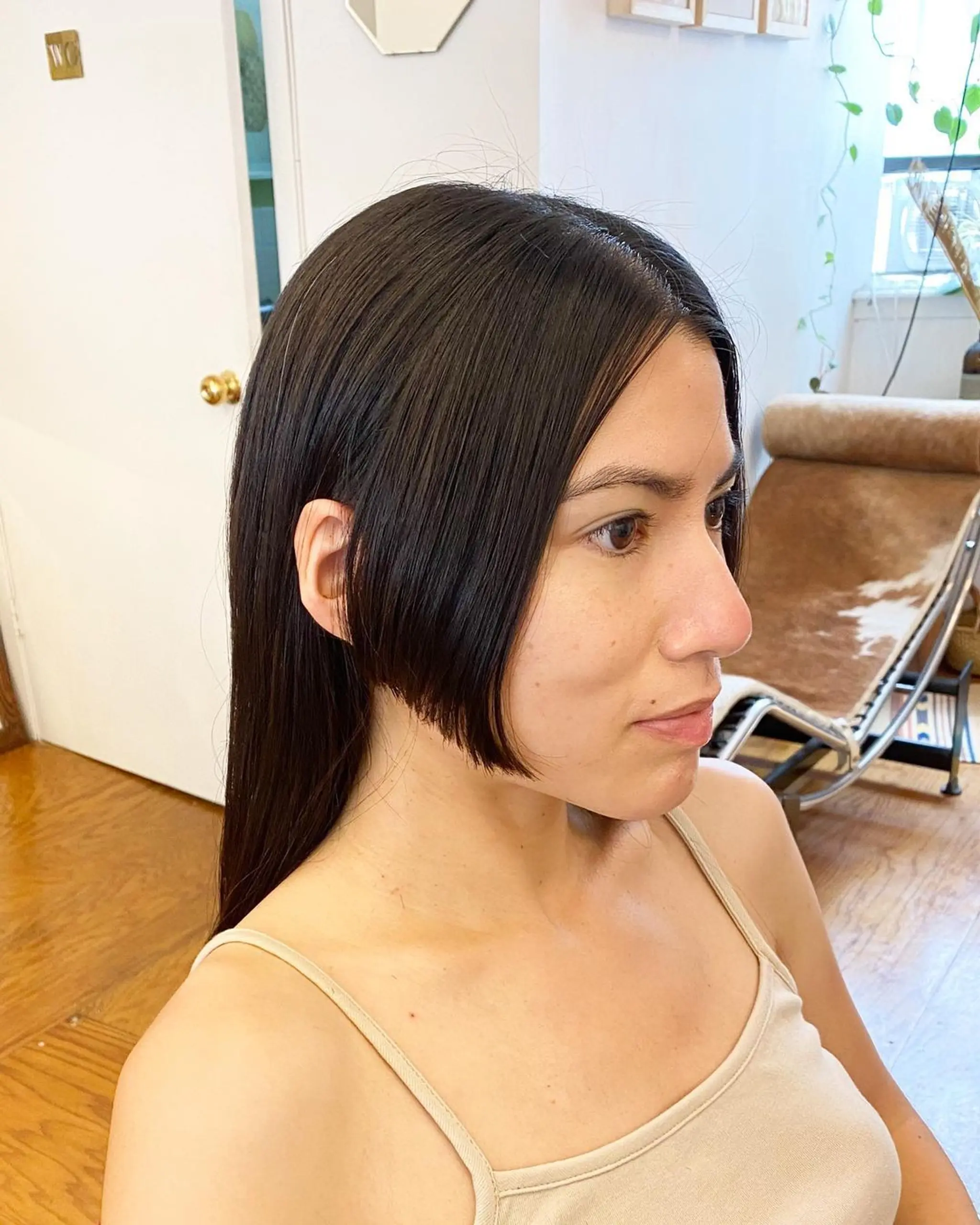 Sleek, straight black hair with a side part. Features include a glossy finish, chin-length face-framing strands, and a polished, asymmetrical look.