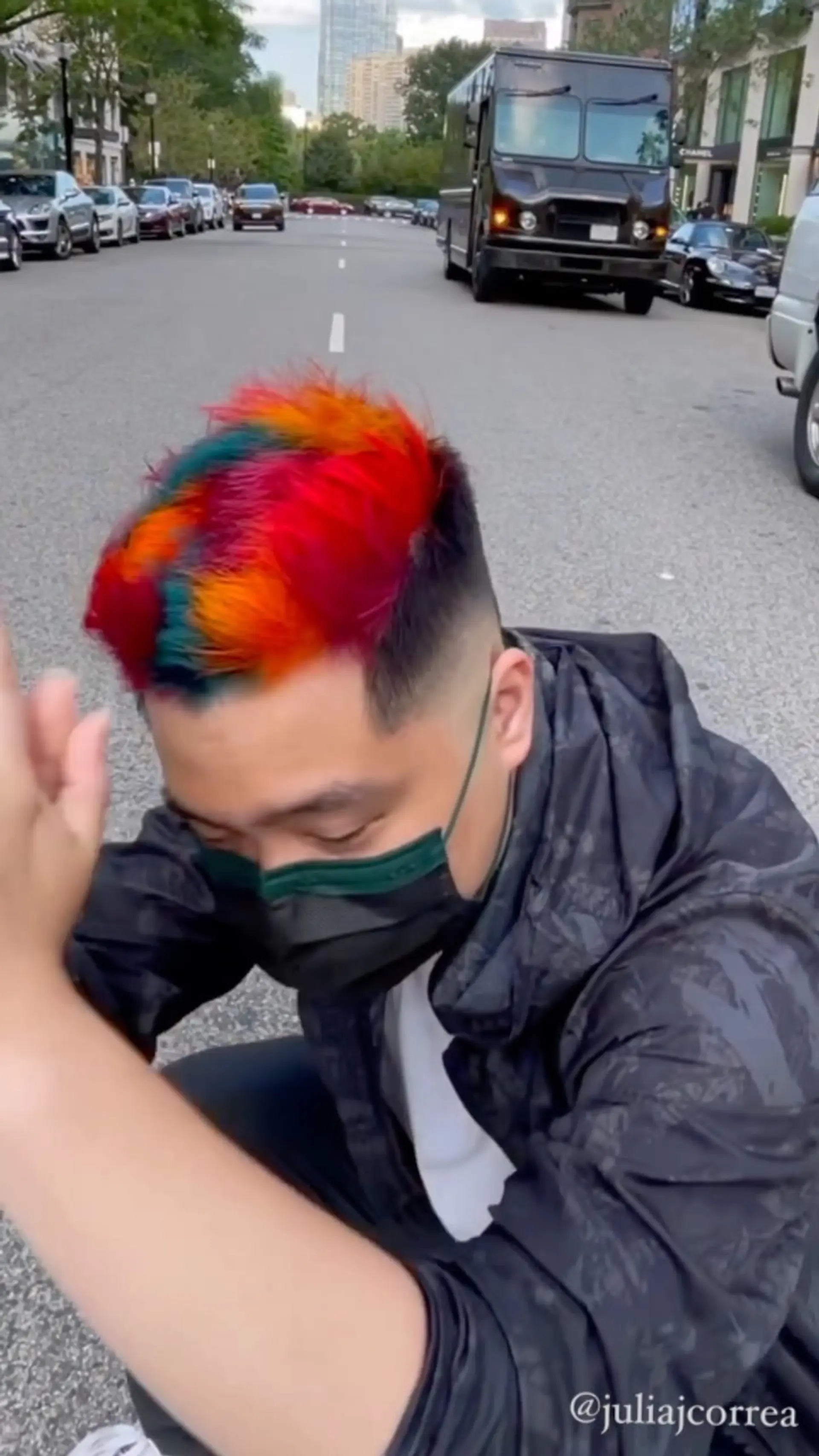 A sharp men's fade featuring vibrant multicolor panels of bright red, fiery orange, and teal across the textured top. 1