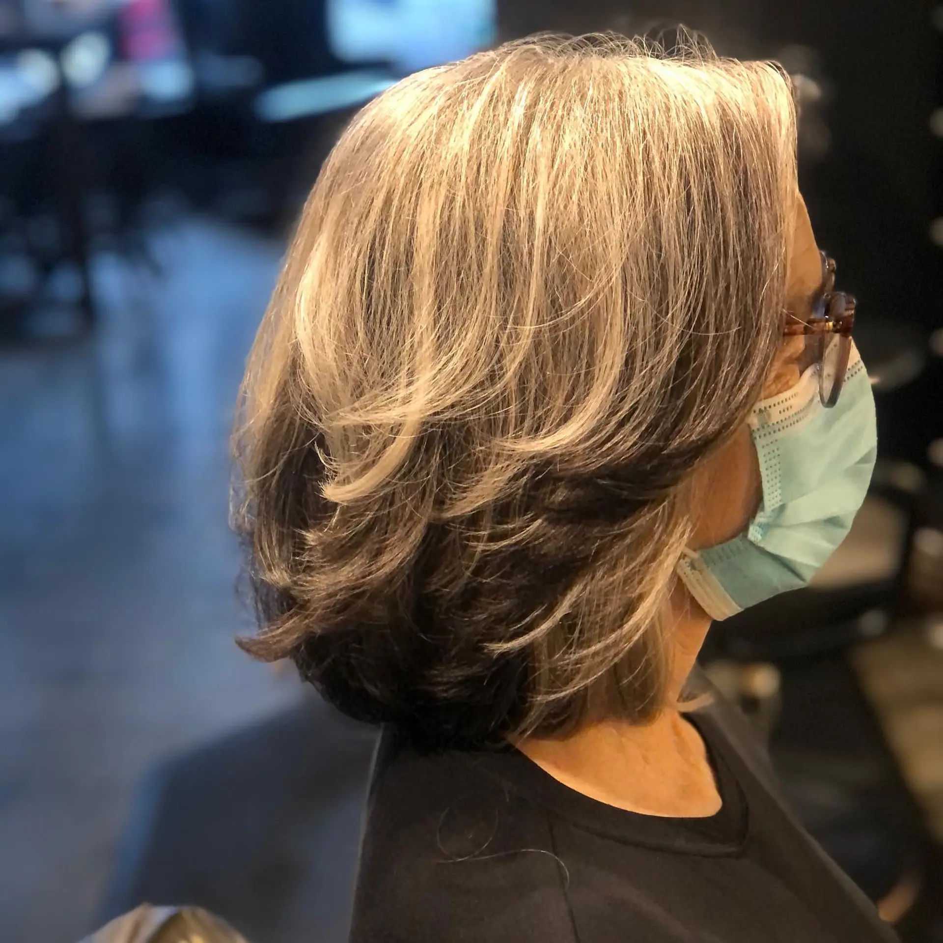 A feathered, layered bob with dimensional silver-gray layers swept back over a dark underlayer. 1