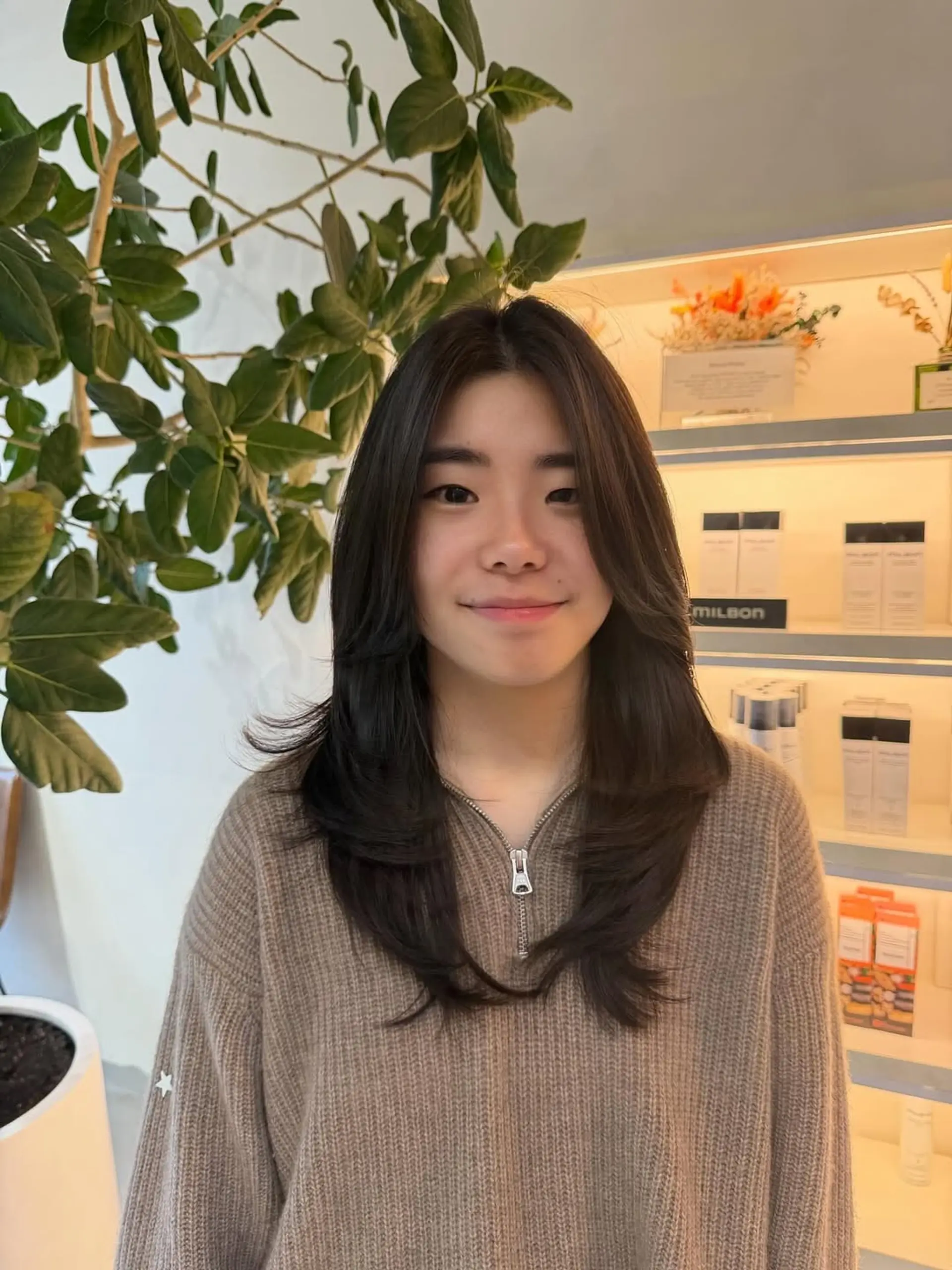 A sophisticated long haircut featuring soft, flowy layers that start around the chin, designed to frame the face and provide voluminous, airy movement to straight hair. 1