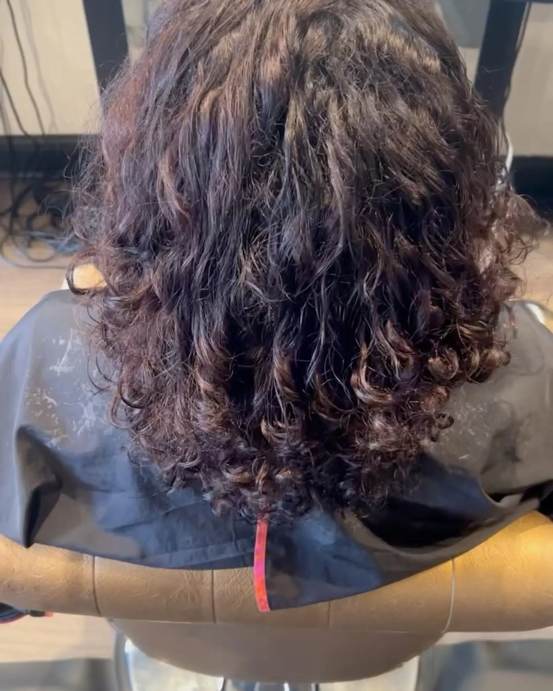 Shoulder-length curly dark brown hair with defined, textured curls and rich dimensional shine. 1