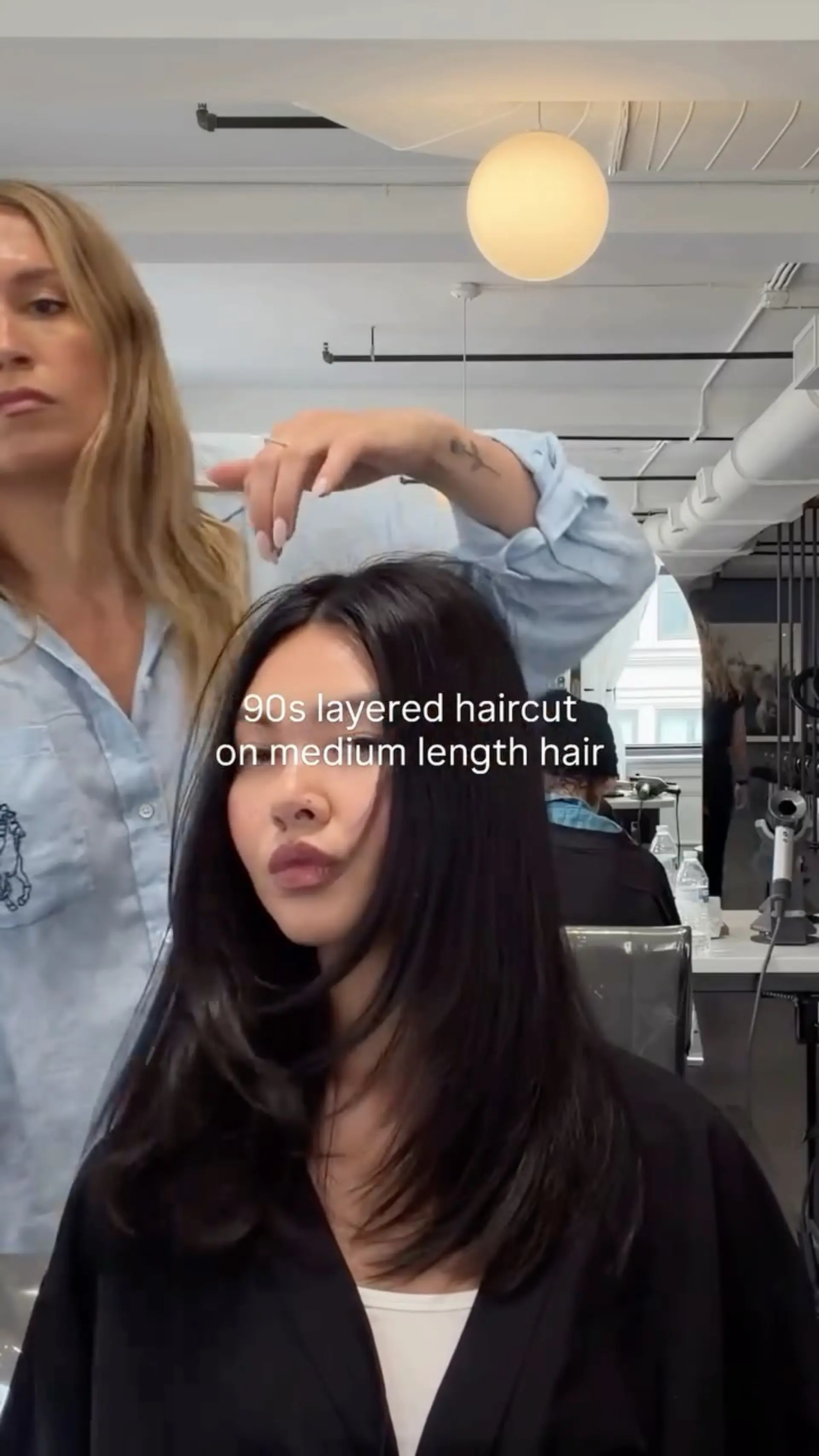 Medium-length layered haircut with 90s-inspired face-framing layers styled with curved ends. 1