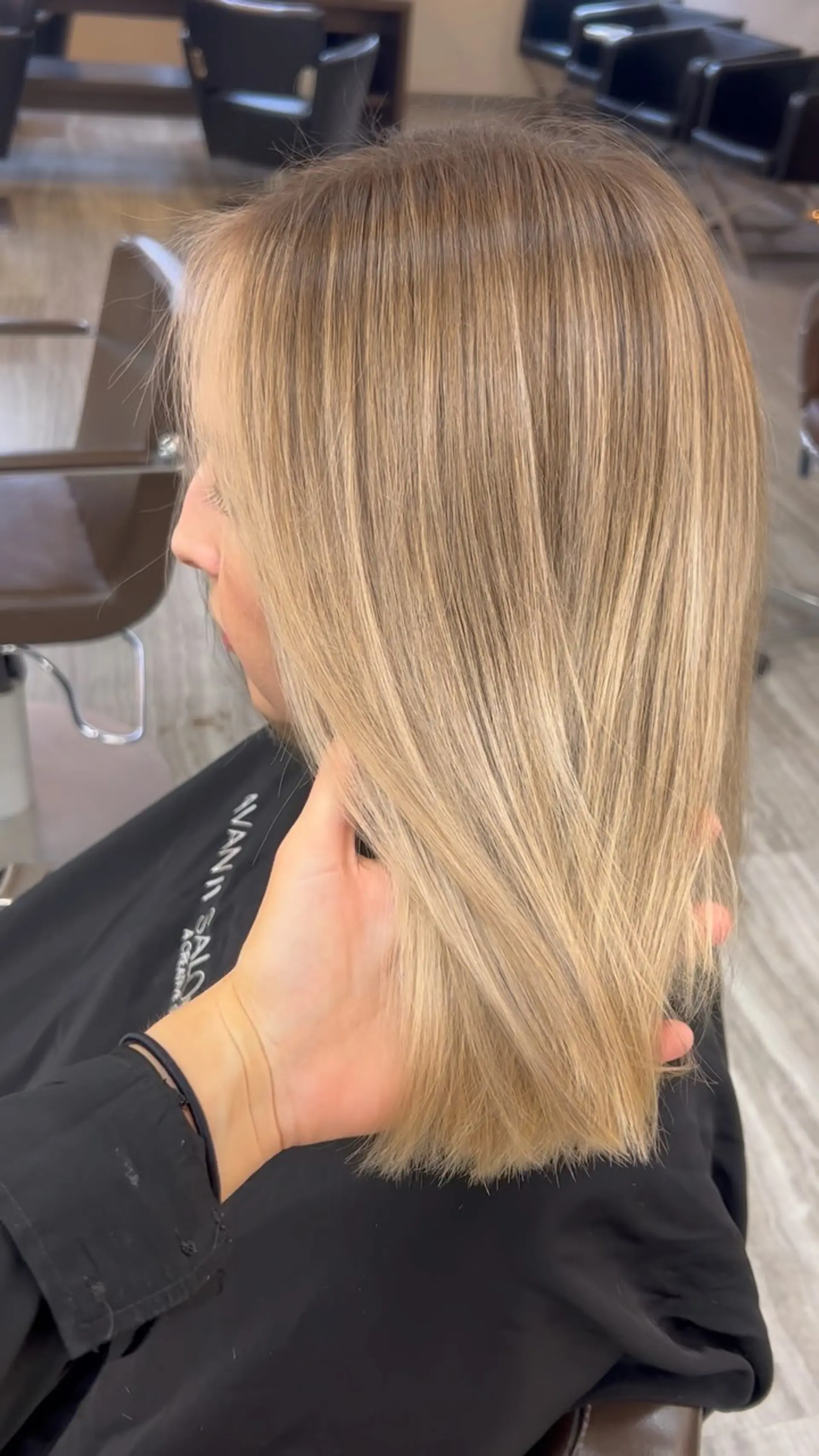 A sleek, shoulder-length straight style featuring full blonde highlights softened at the root with a seamless color melt. 1