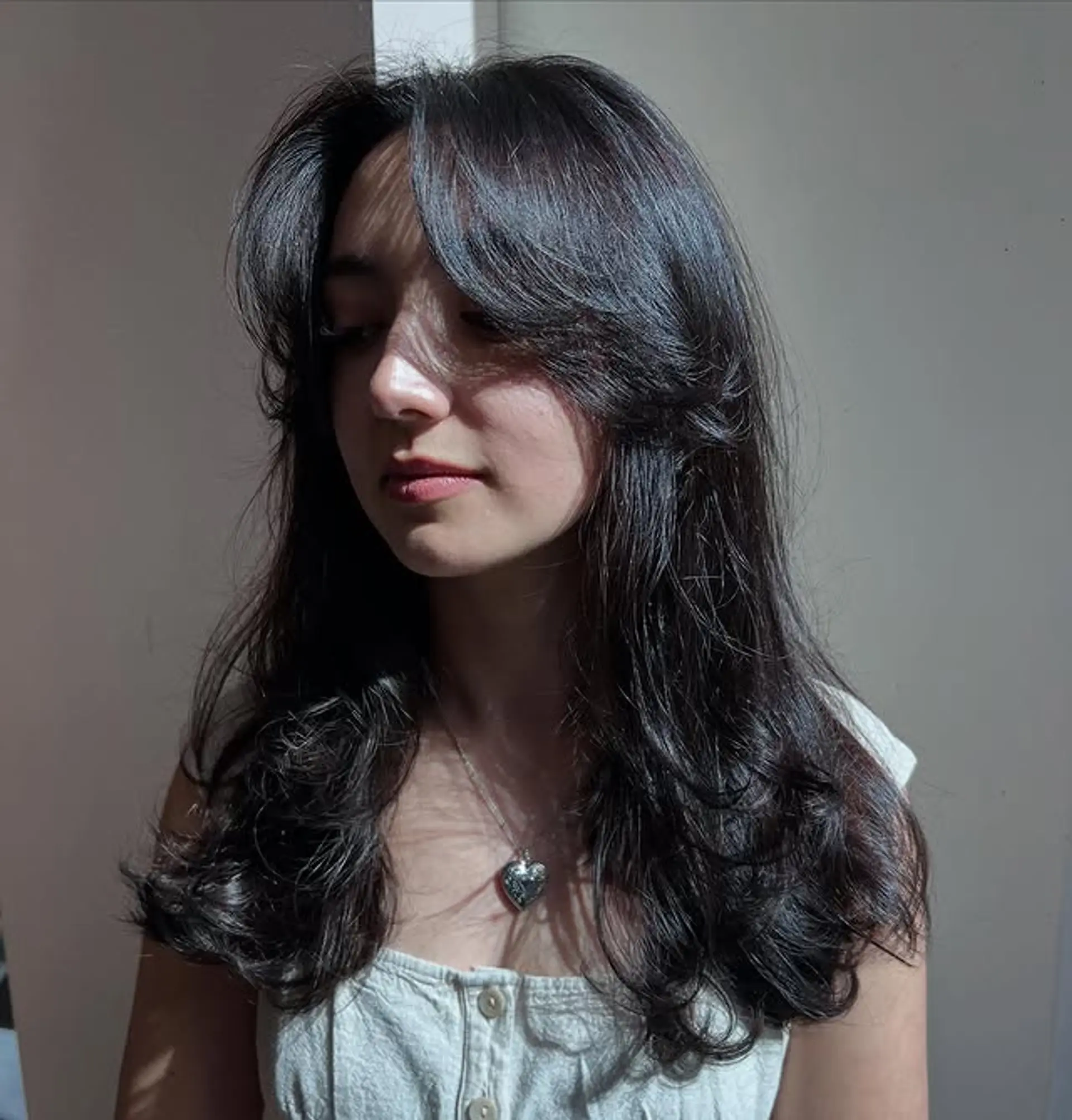 A long, layered haircut with curtain bangs. 1