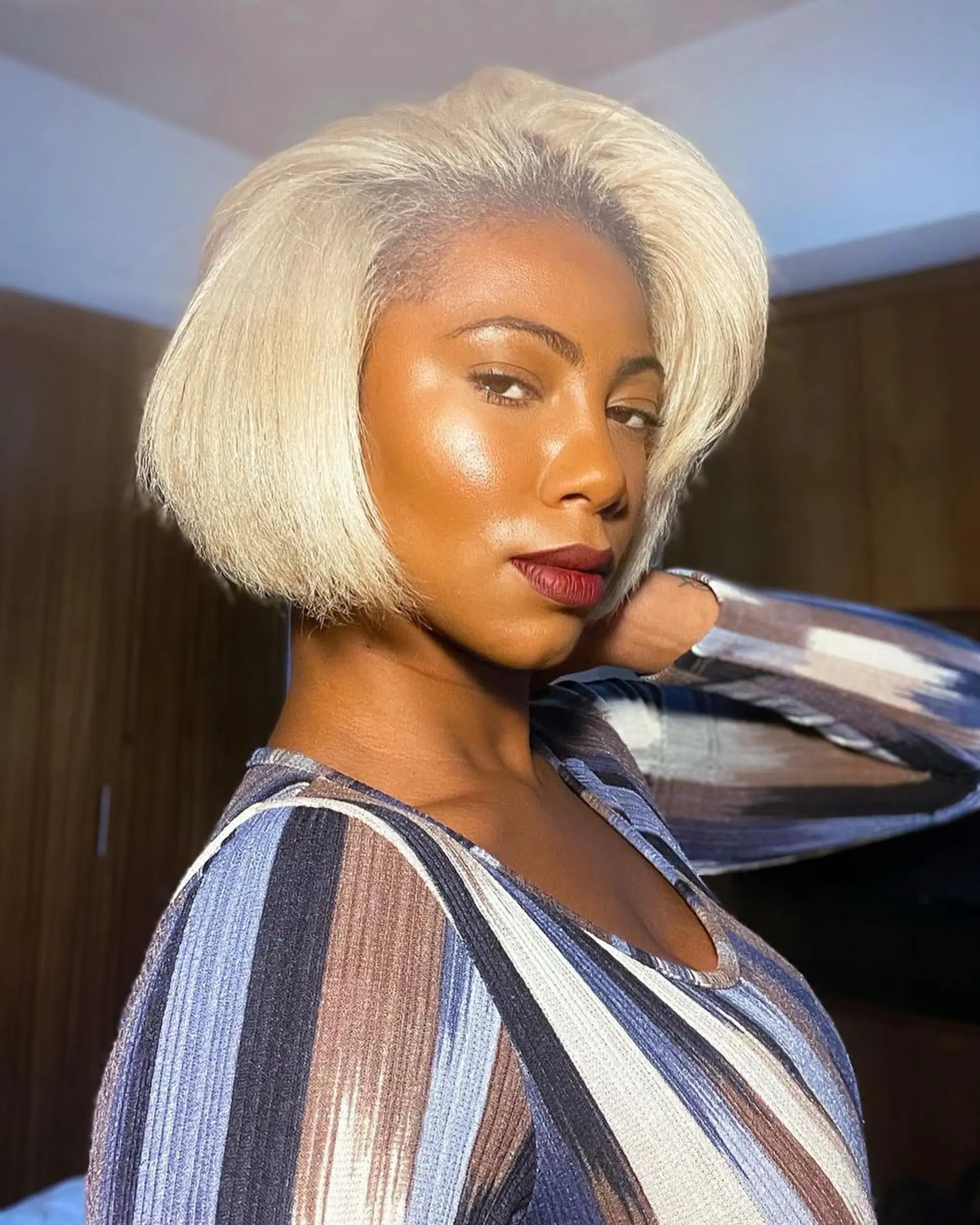 A sleek, side-parted bob with platinum blonde coloring. The hair is cut short, with a subtle taper inwards at the ends, straight texture, and a smooth finish. 3