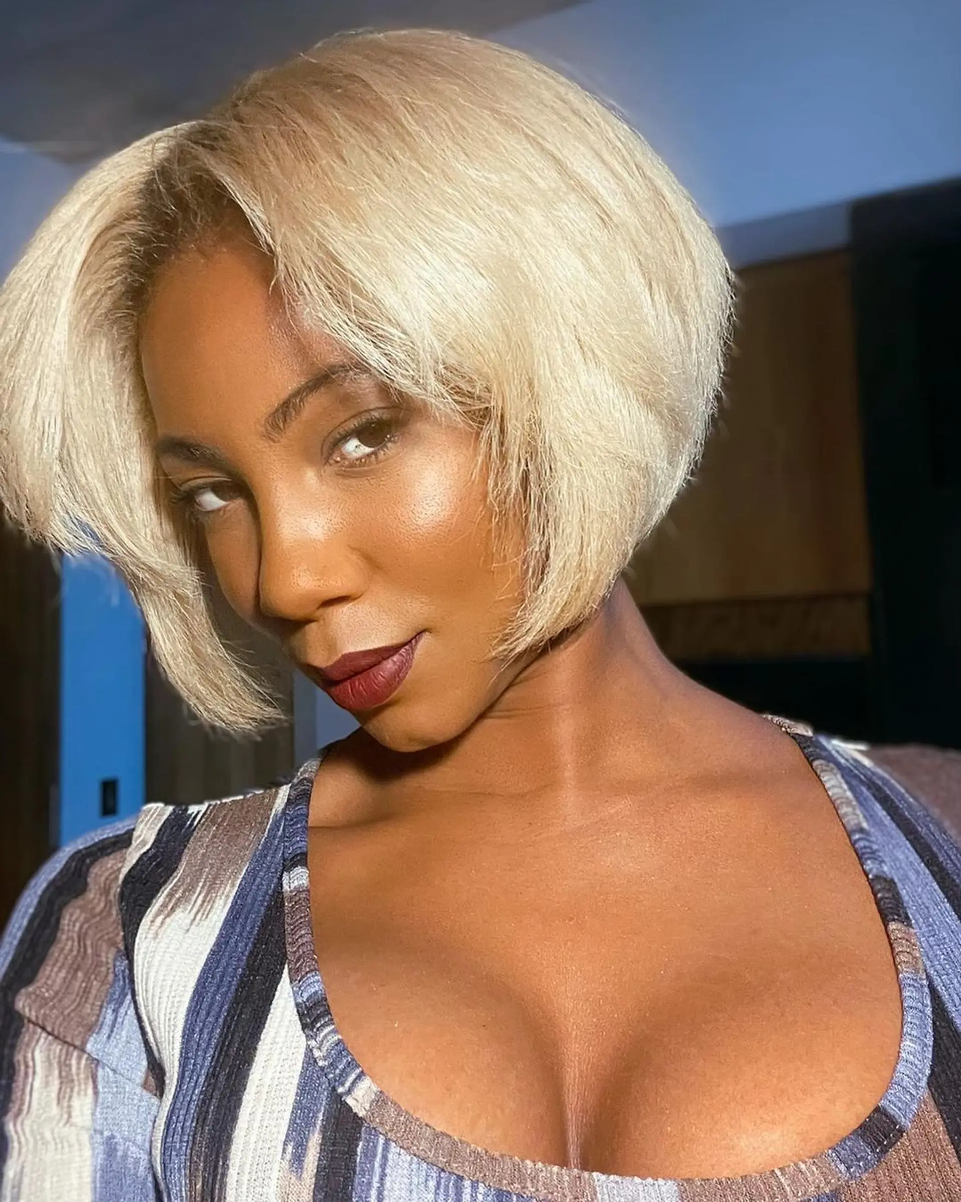 A sleek, side-parted bob with platinum blonde coloring. The hair is cut short, with a subtle taper inwards at the ends, straight texture, and a smooth finish. 1