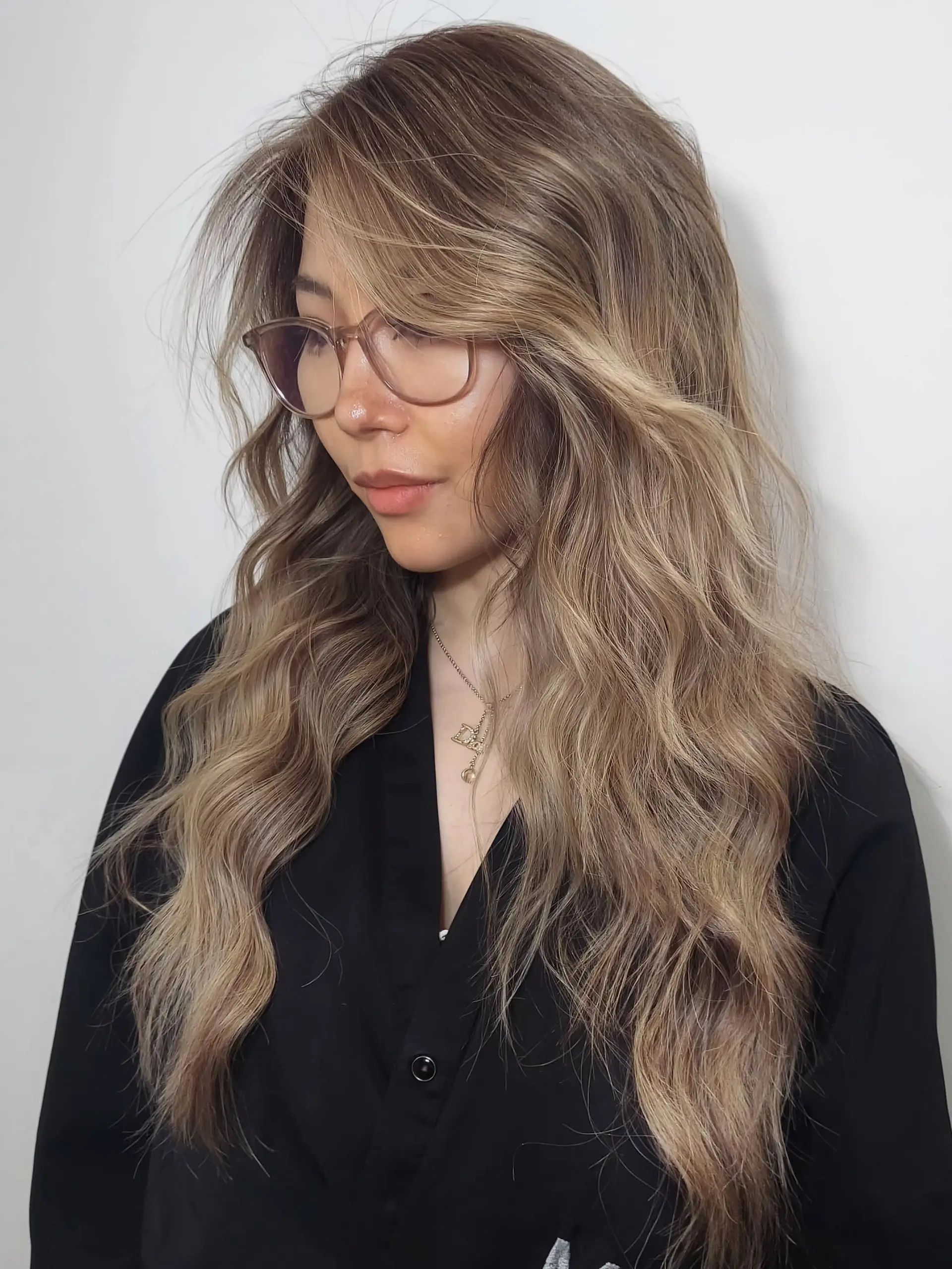 Long, wavy hair featuring a soft beige brown foilayage color blend. 1
