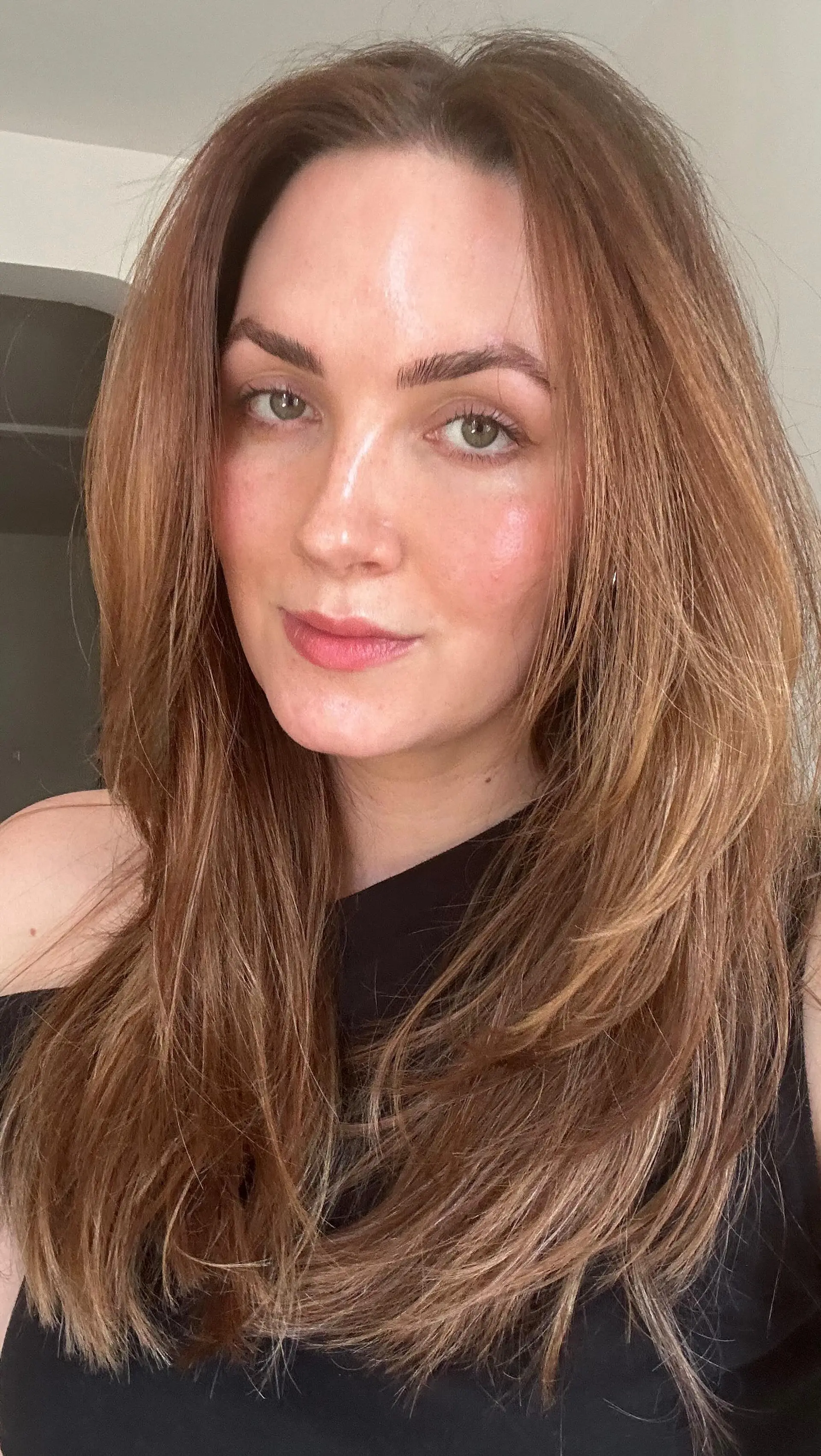 Long warm copper-auburn hair cut with feathered face-framing layers and styled into a sleek, voluminous blowout. 1