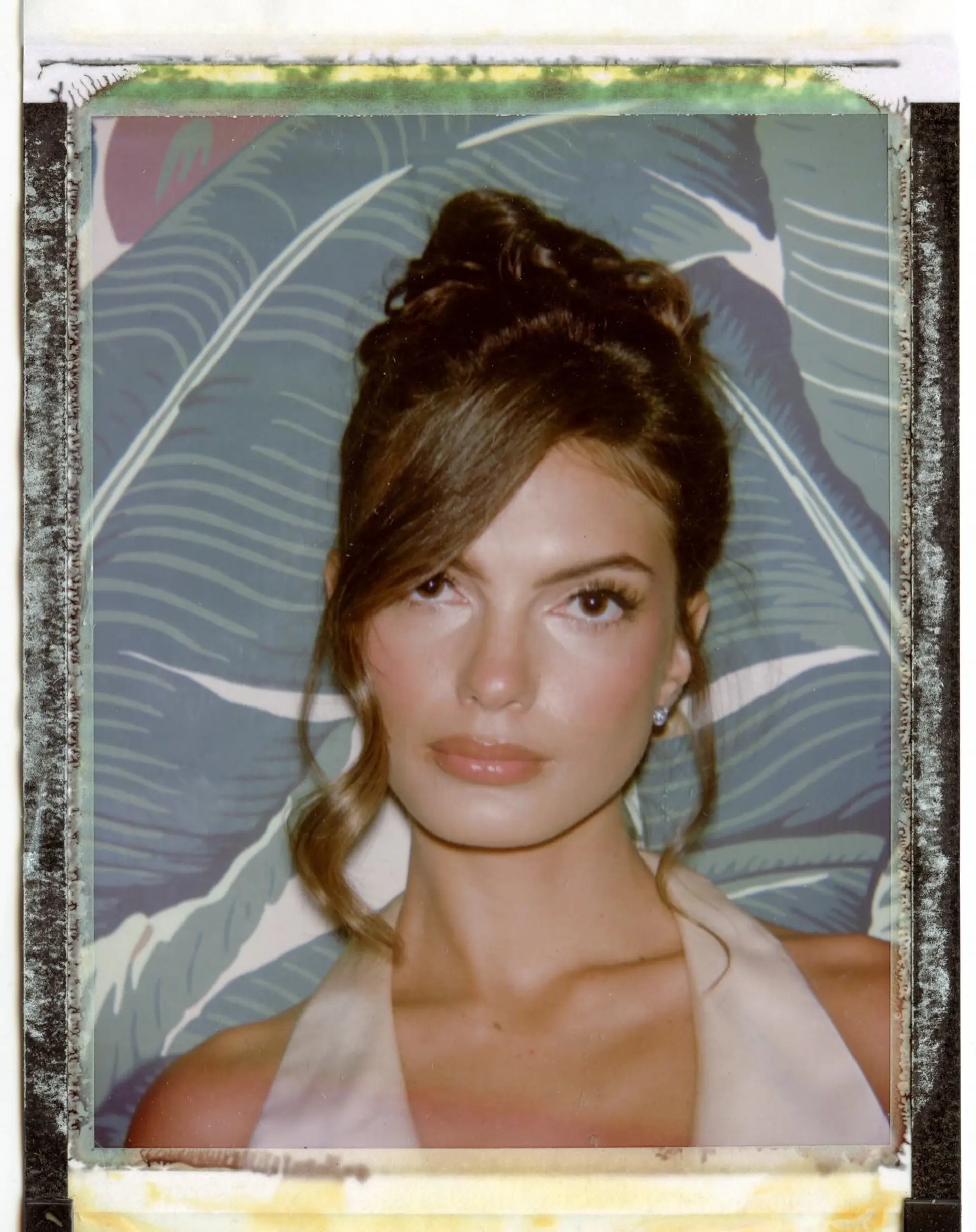 An elegant high updo with soft texture, side-swept bangs, and wavy tendrils framing the face. 1