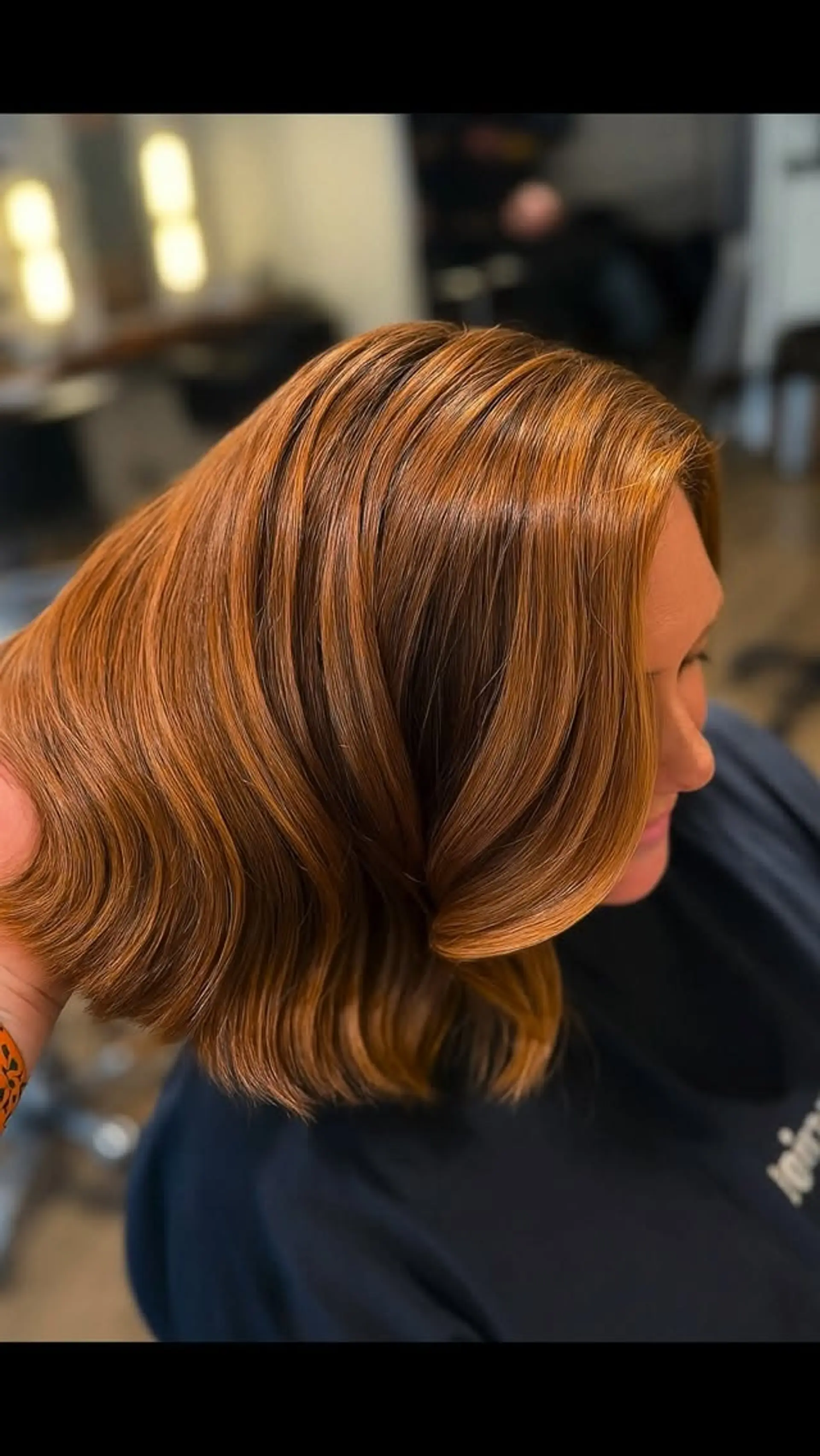 A rich copper lob featuring soft, dimensional painted ribbons and brushed-out waves for a high-shine, glossy finish. 1