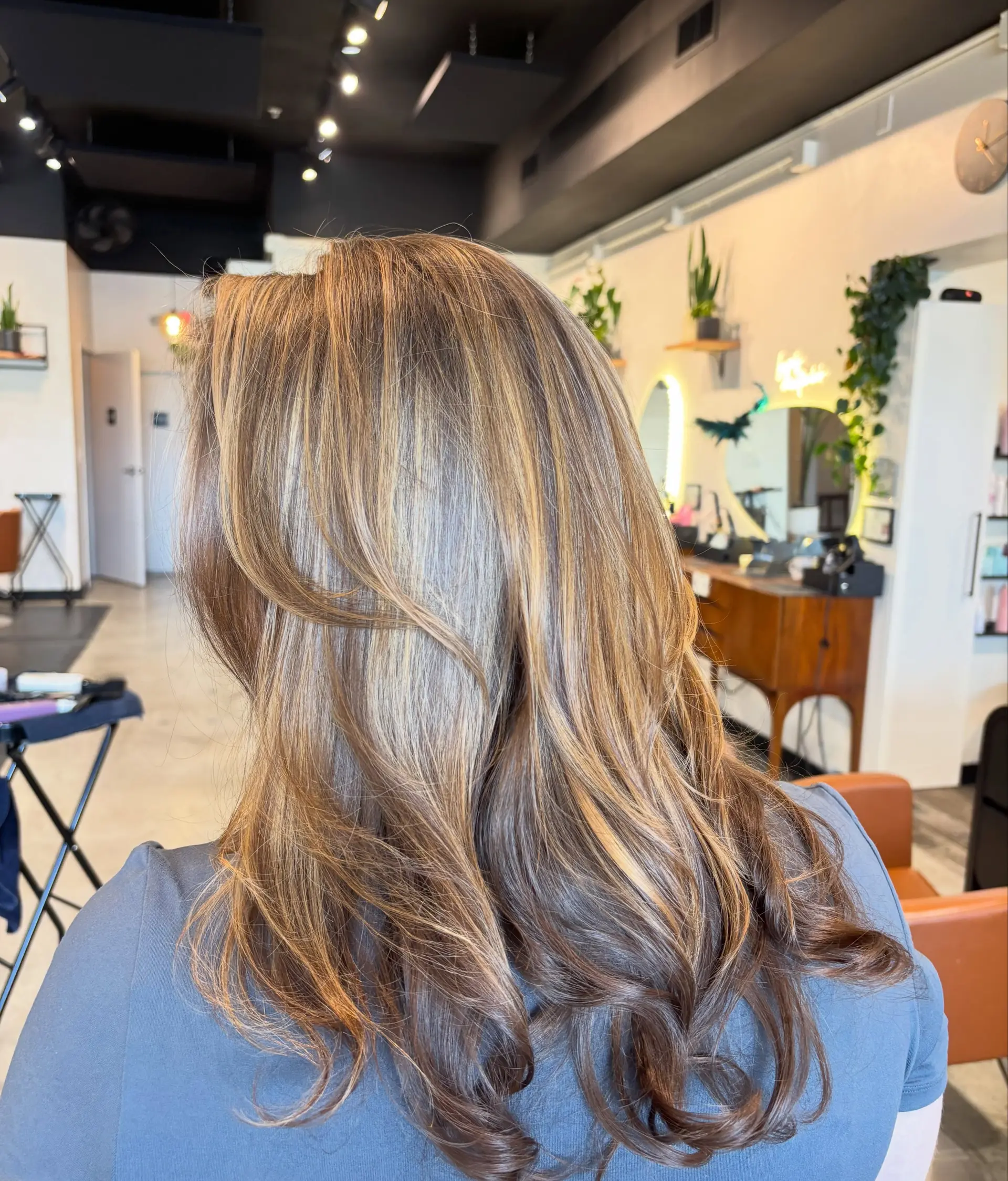 Long layered hair featuring soft, multidimensional warm caramel and golden blonde balayage with curled ends. 1