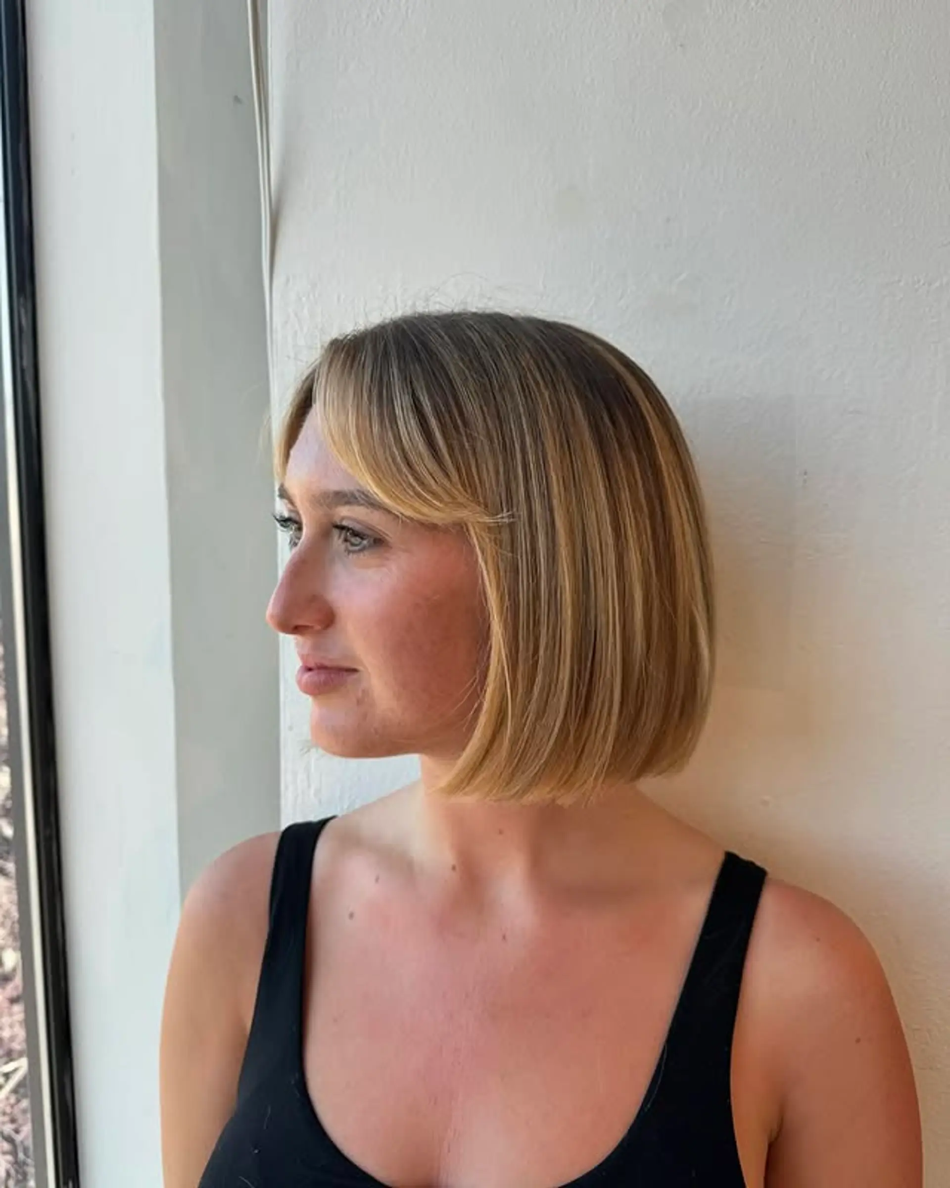 A classic blunt bob haircut featuring soft, face-framing bangs. 1