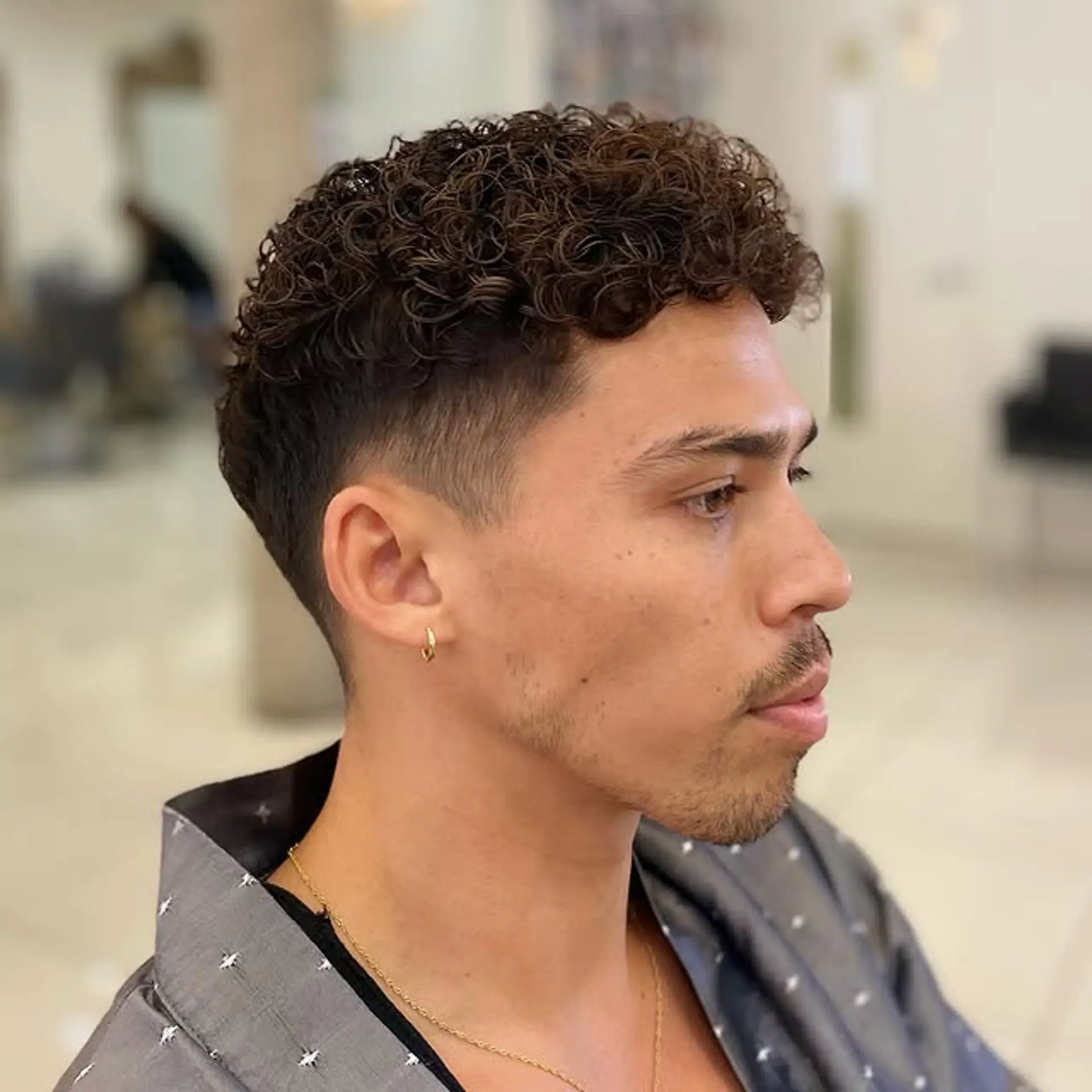 Defined curls on top with a clean taper fade on the sides and back. 1