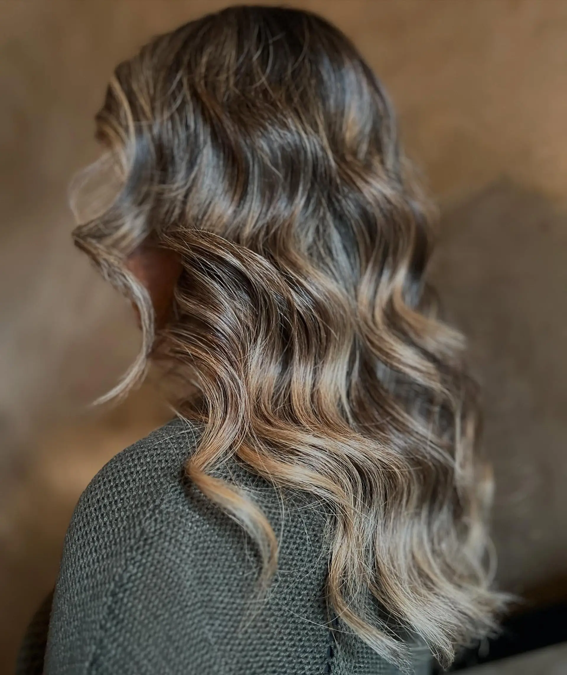 Long flowing hair styled in loose, dimensional waves featuring a blended cool brunette to ash bronde balayage. 1