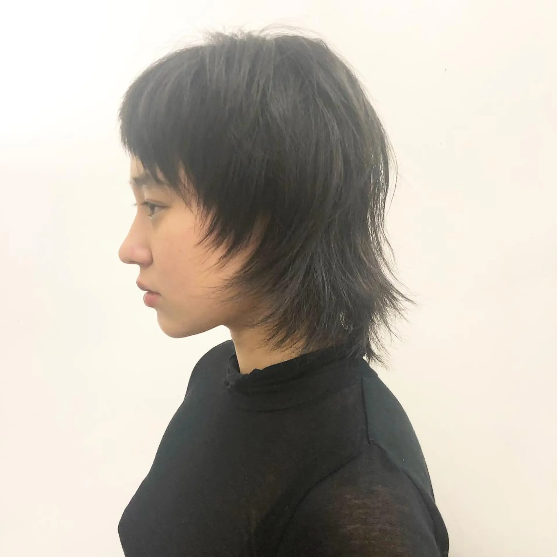 A  layered mullet cut with a bold, choppy fringe. The hair is straight and cut short with textured layers, giving it volume and movement by Takeo. 1