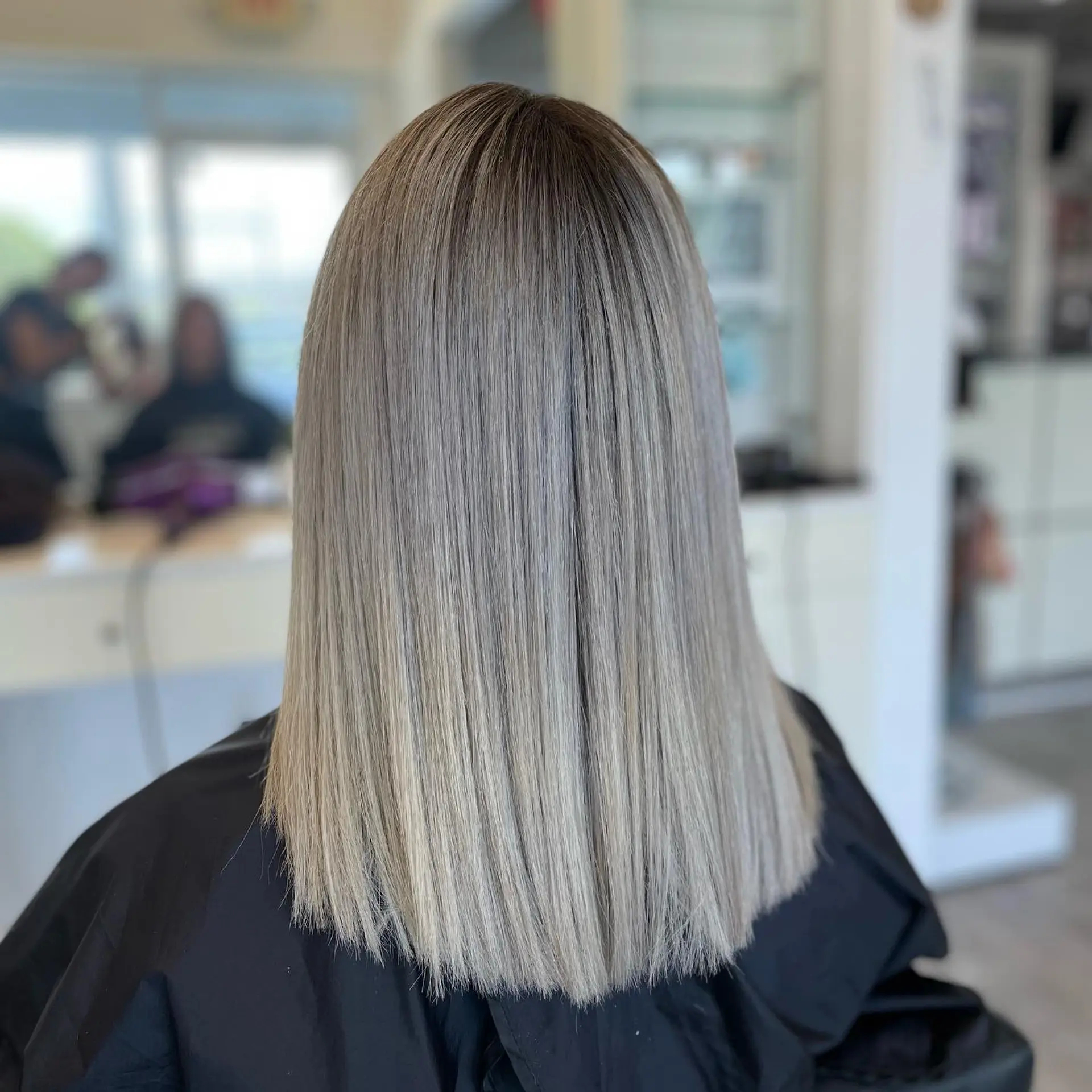 A shoulder-length blunt cut hairstyle with a cool, icy ash blonde color. 1