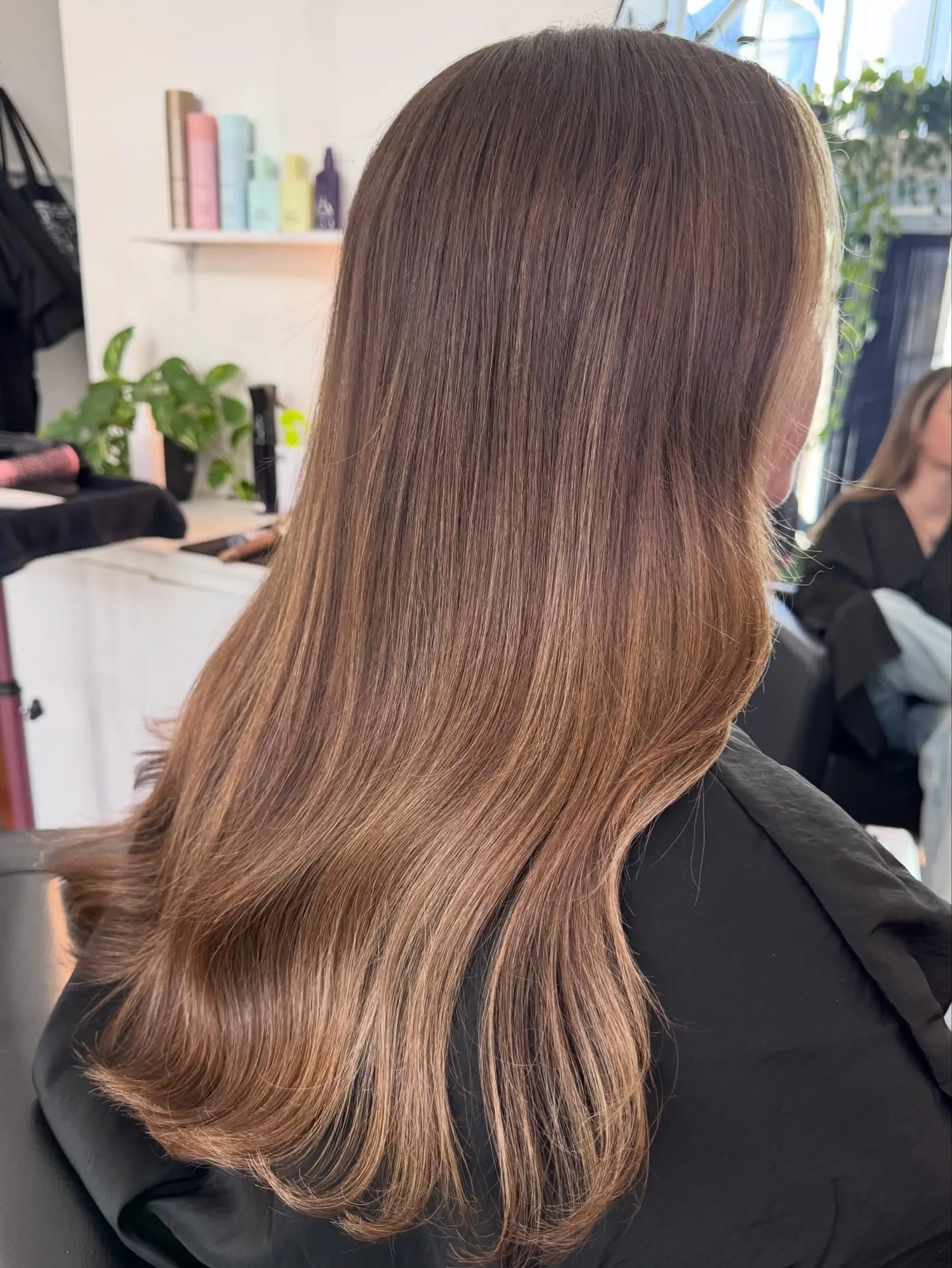 Long, smooth brunette hair detailed with seamless, fine sun-kissed highlights and a soft bend at the ends. 1