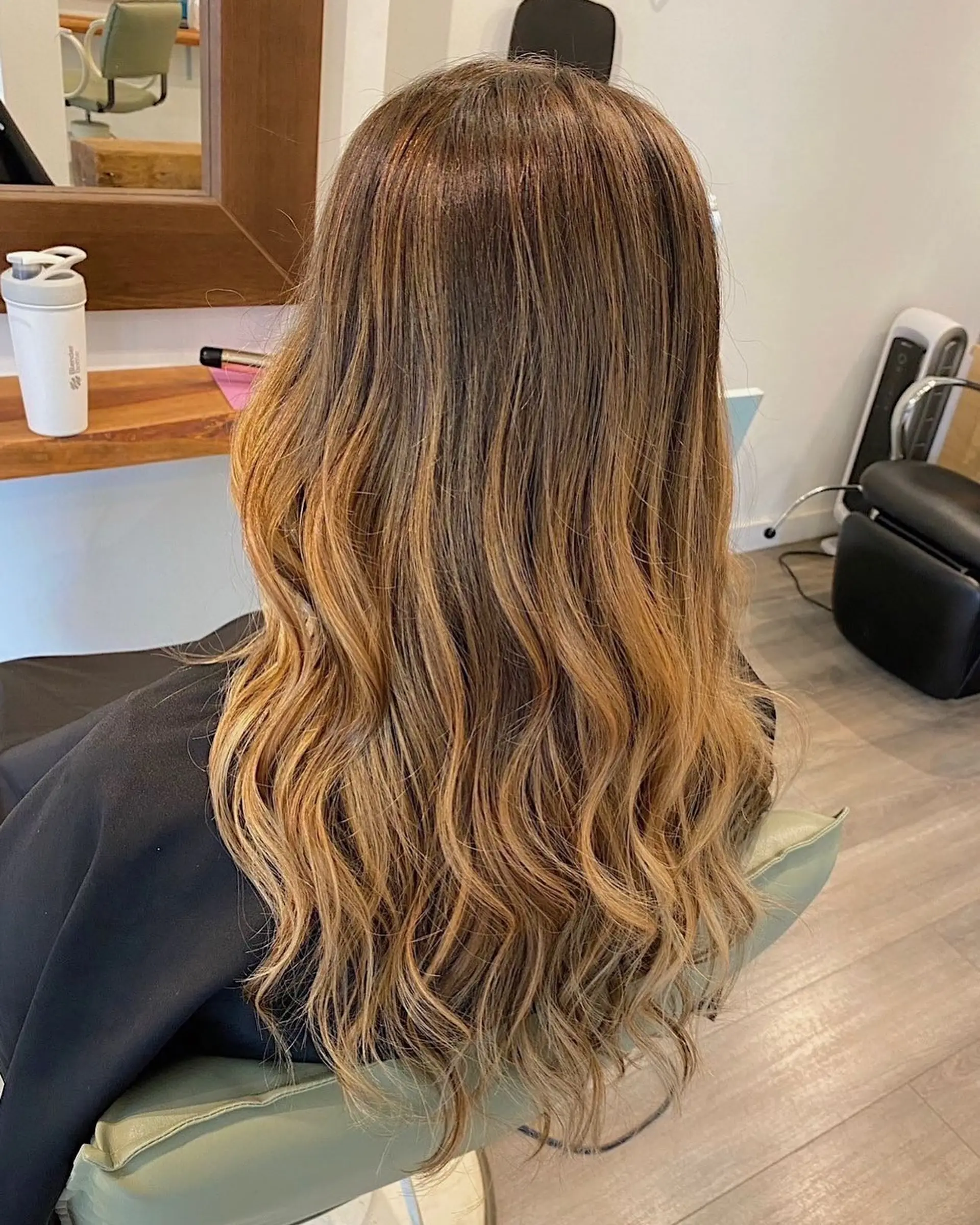 Long, wavy hair with a brown to golden blonde ombre. 1