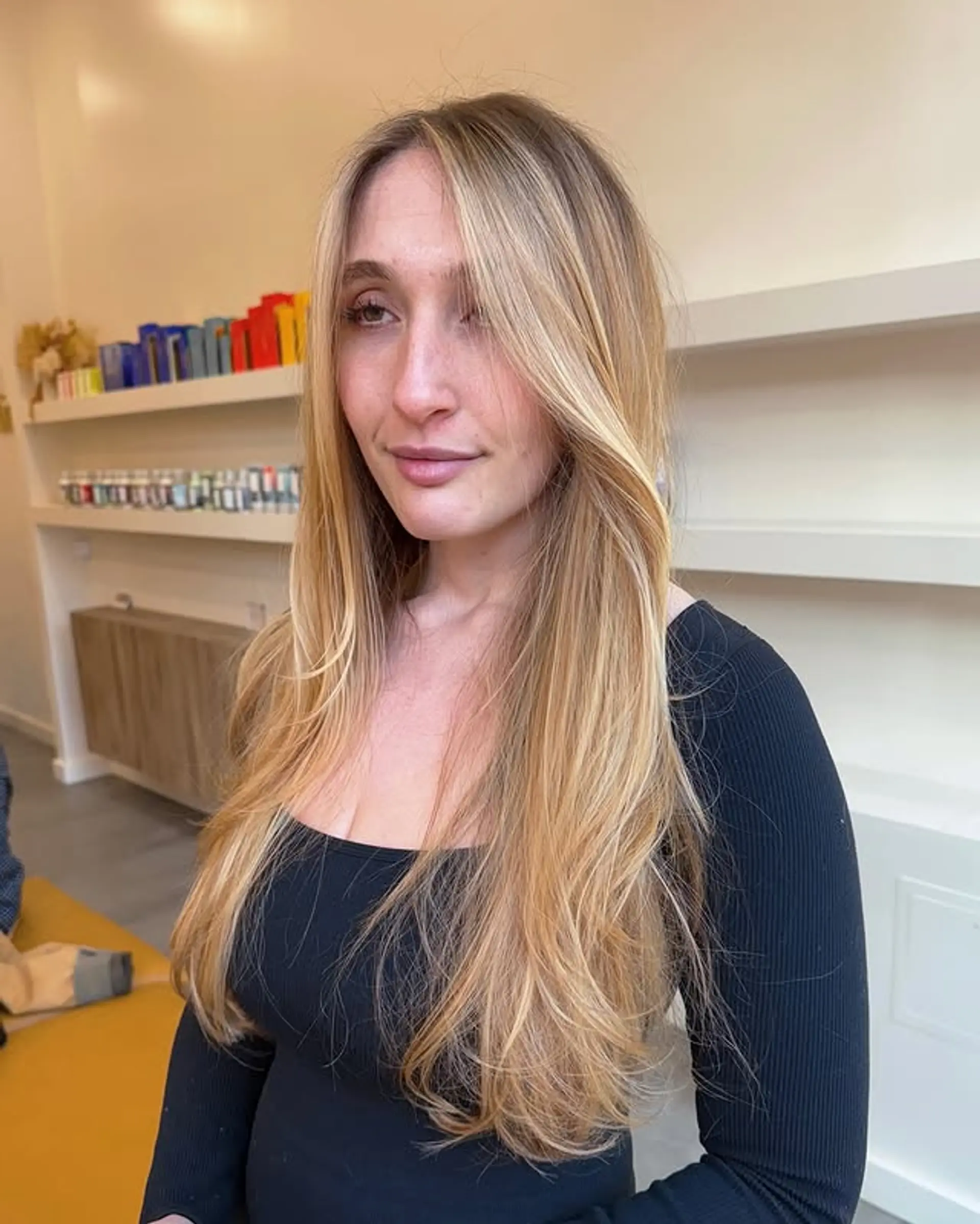 Long, layered hairstyle with face-framing layers and a golden blonde balayage. 1