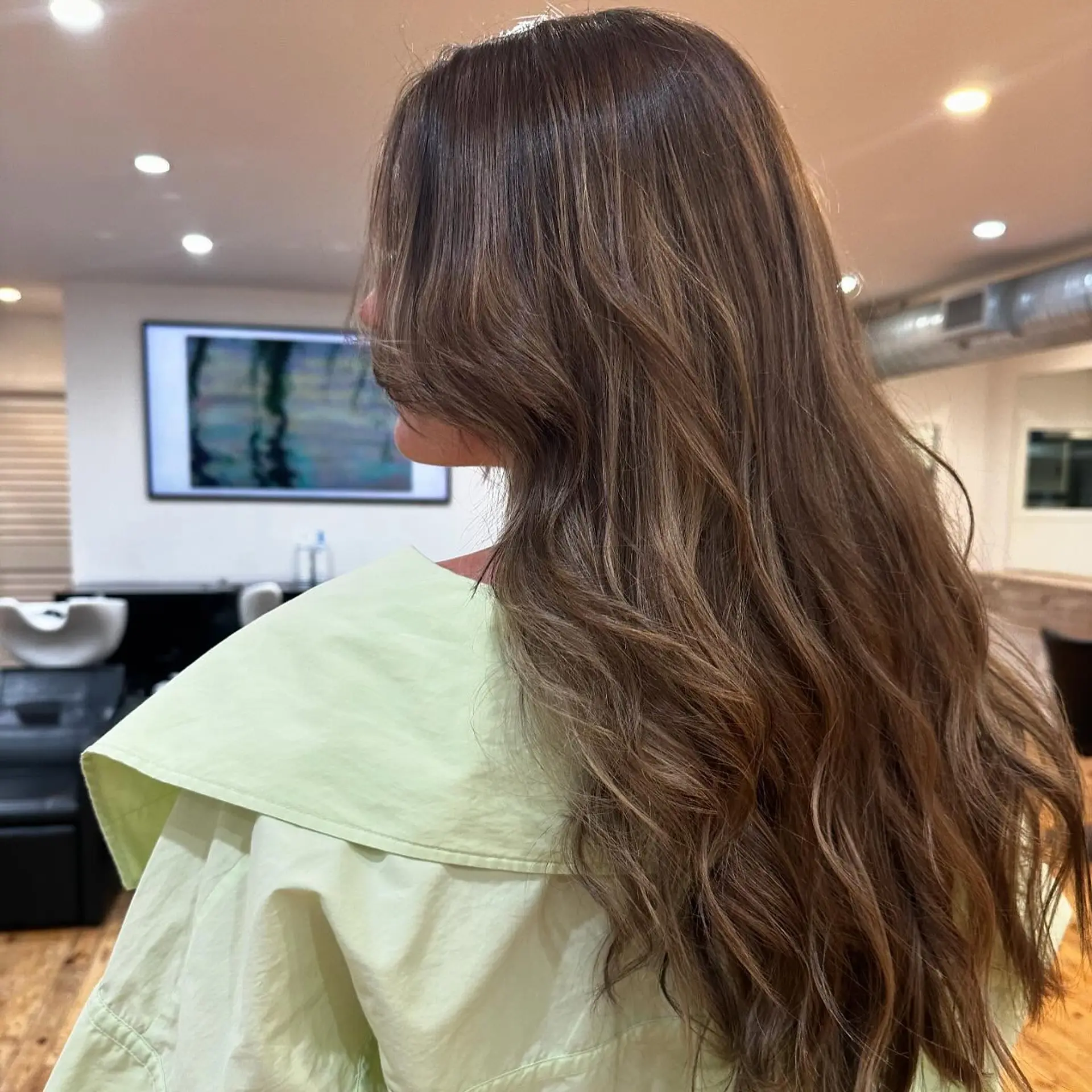 A gorgeous long wavy hairstyle with a bronde balayage, expertly blended for a seamless transition from brunette to blonde. 2