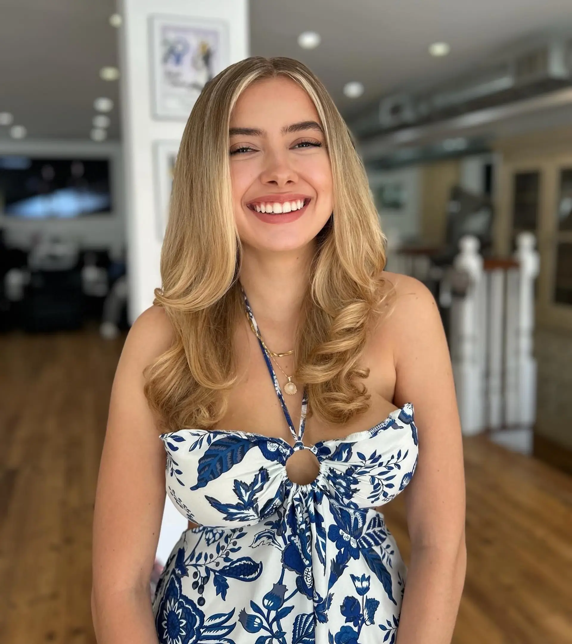 Long, wavy blonde hairstyle with face-framing layers and bouncy curls for a glamorous and beachy vibe. 1