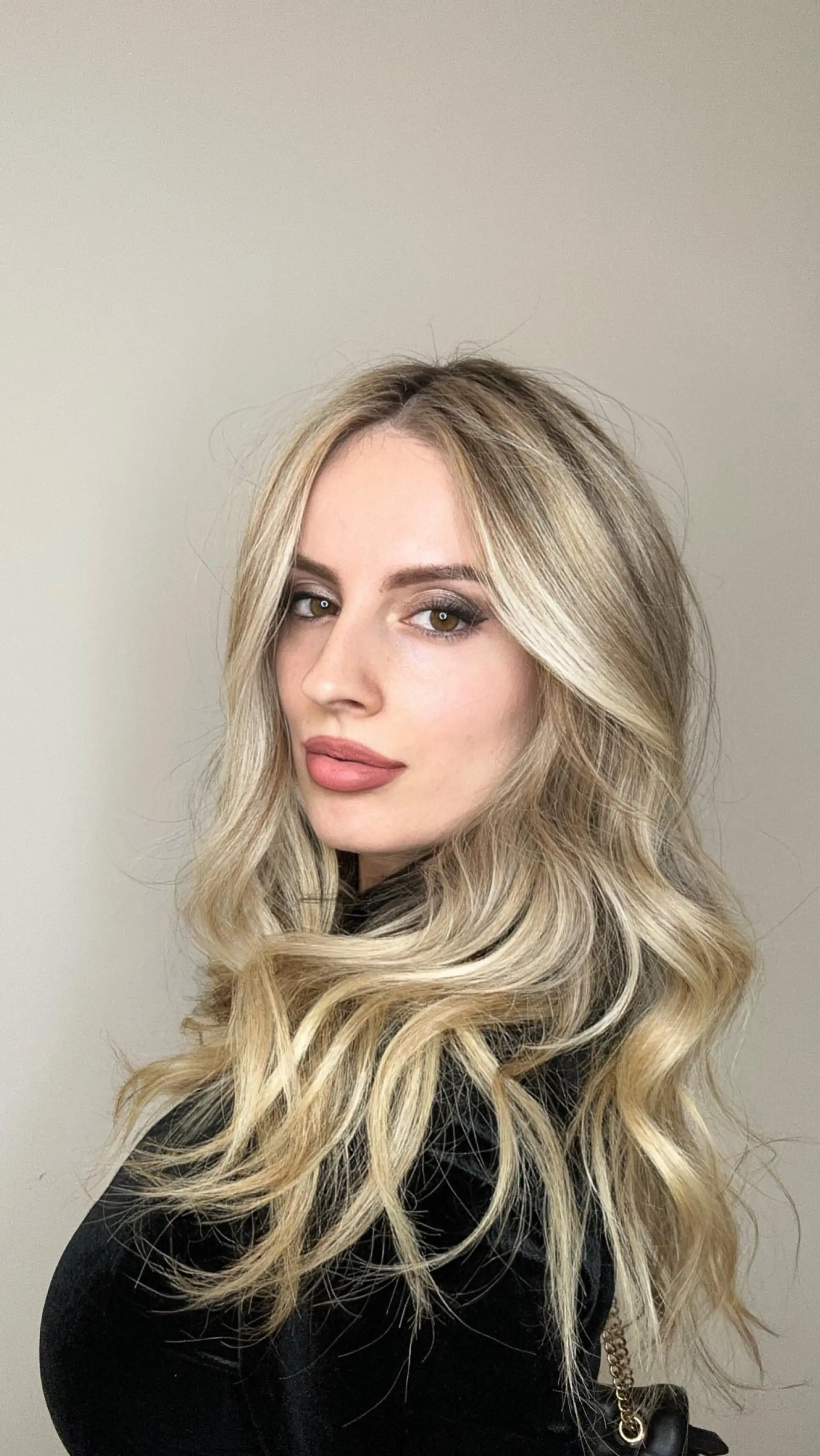 Long dimensional blonde hair styled in soft, cascading waves with bright face-framing pieces. 1