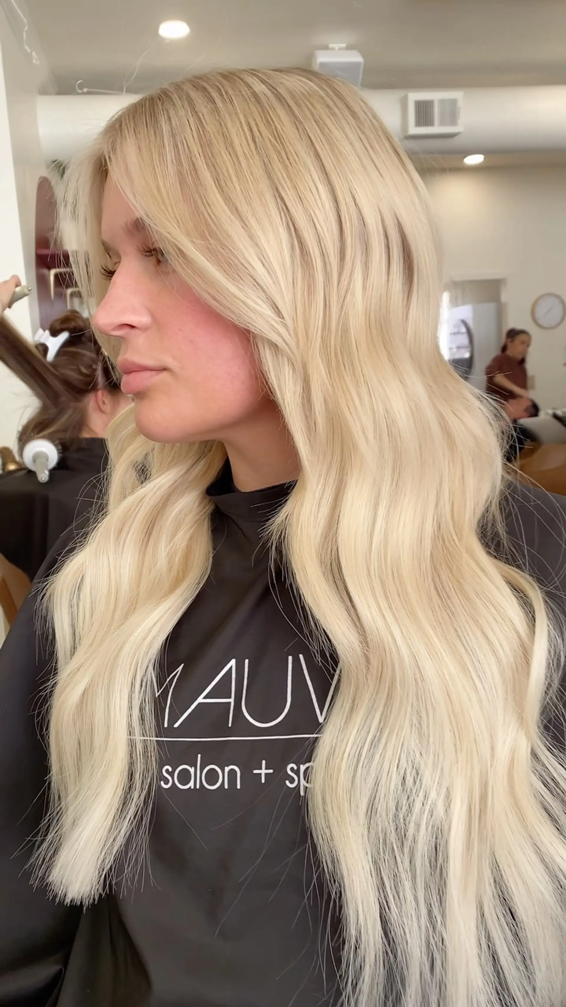 Long platinum blonde hair styled into soft, flowing waves with seamless face-framing layers. 1