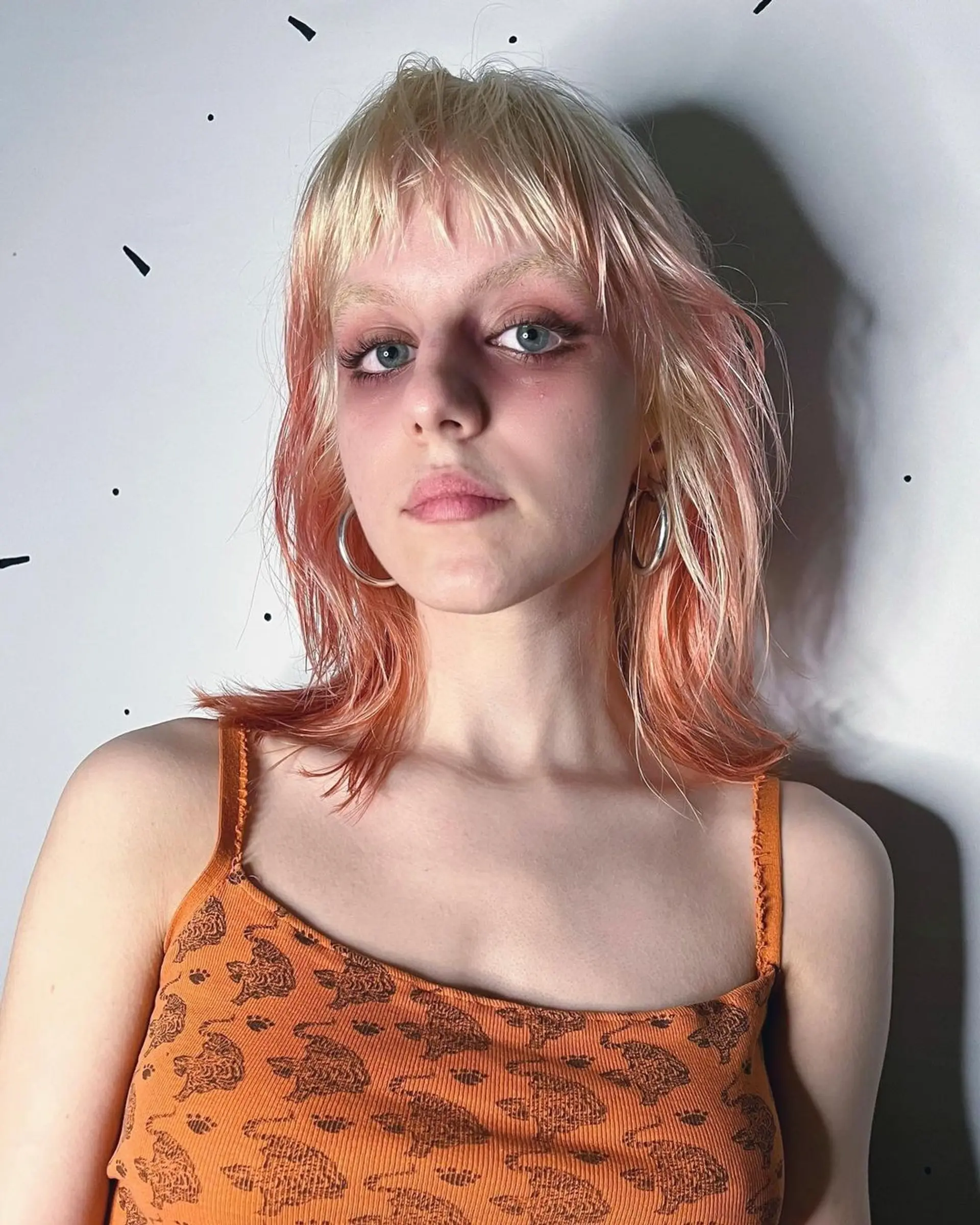 Medium length, wavy hair with fringe bangs, layered and triple-tone in blonde and peach and orange hues. 2