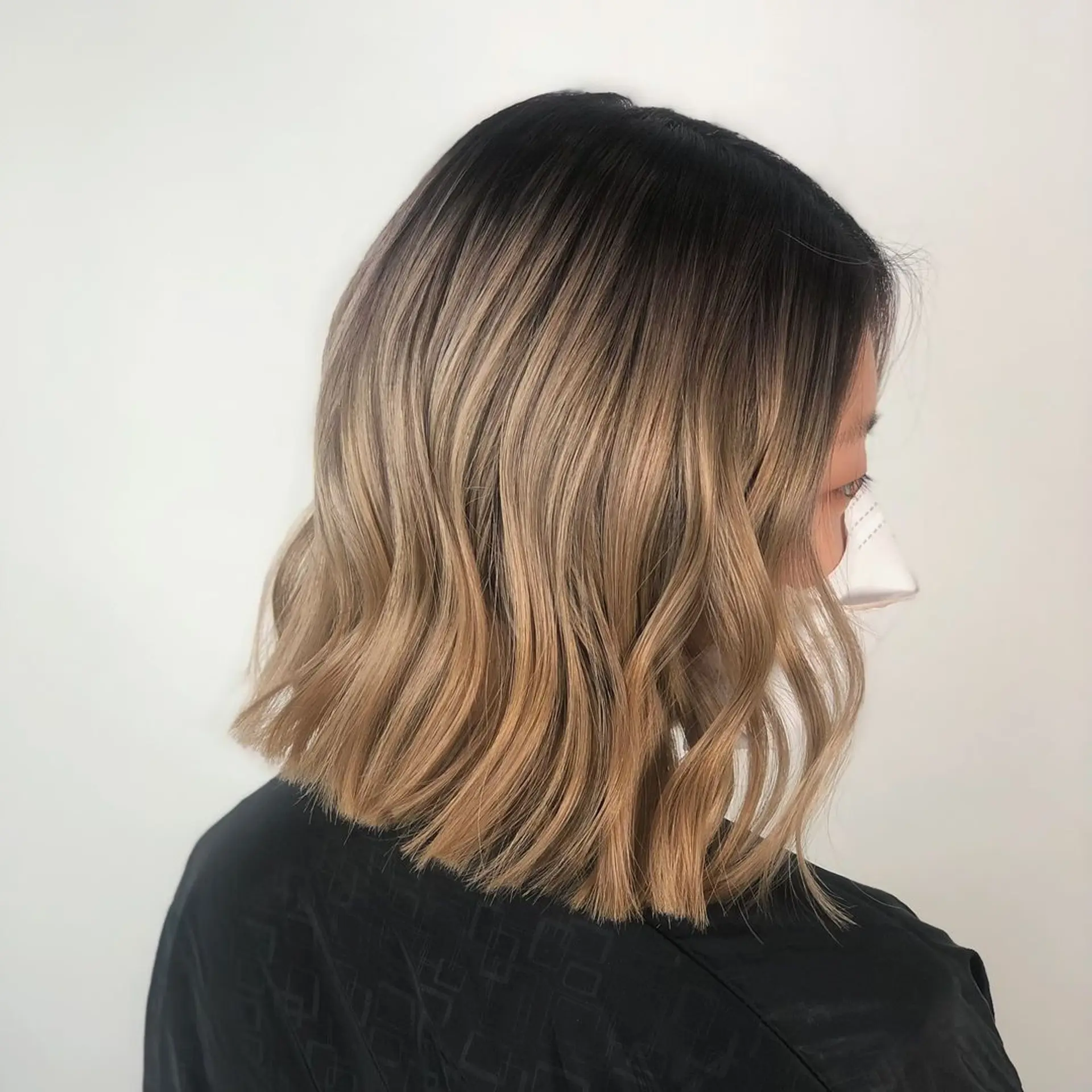 Medium-length wavy hair with an ombre transition from dark brown roots to golden blonde tips, featuring soft and relaxed waves with a blunt cut.
Stylist - @xcellent_jason 1