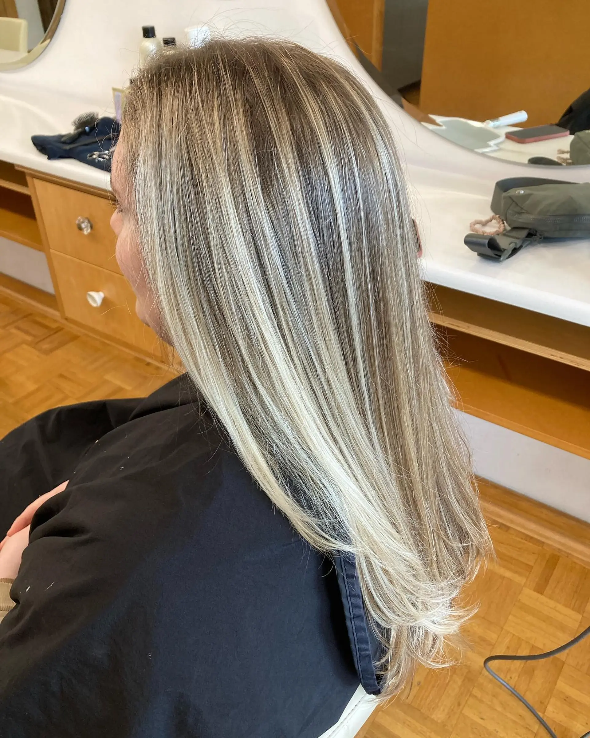 Long straight hair featuring multidimensional cool blonde highlights over a light brown base with a sleek blowout finish. 1