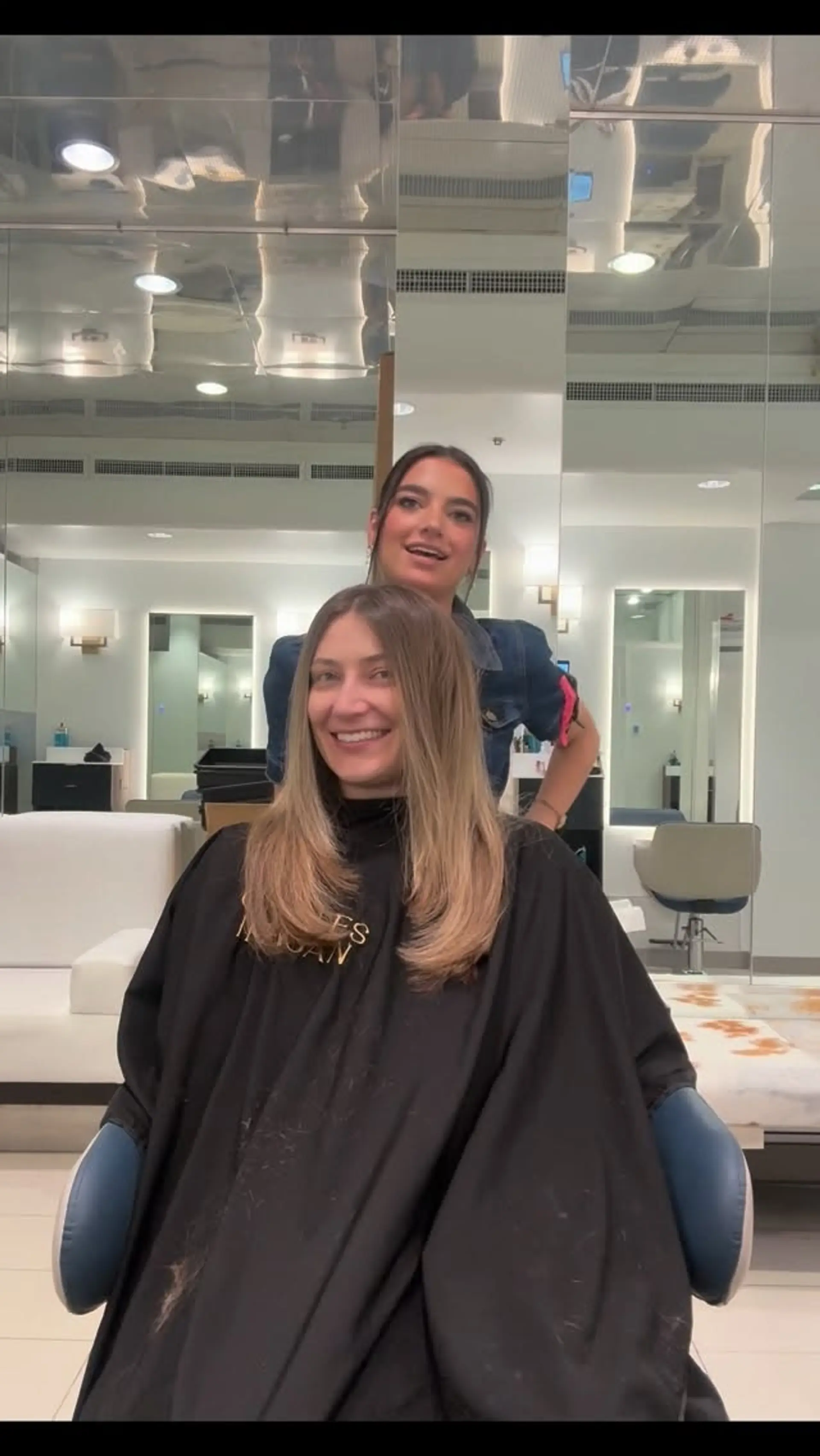 Long layered haircut styled with a smooth blowout and soft curved ends framing the shoulders. 1